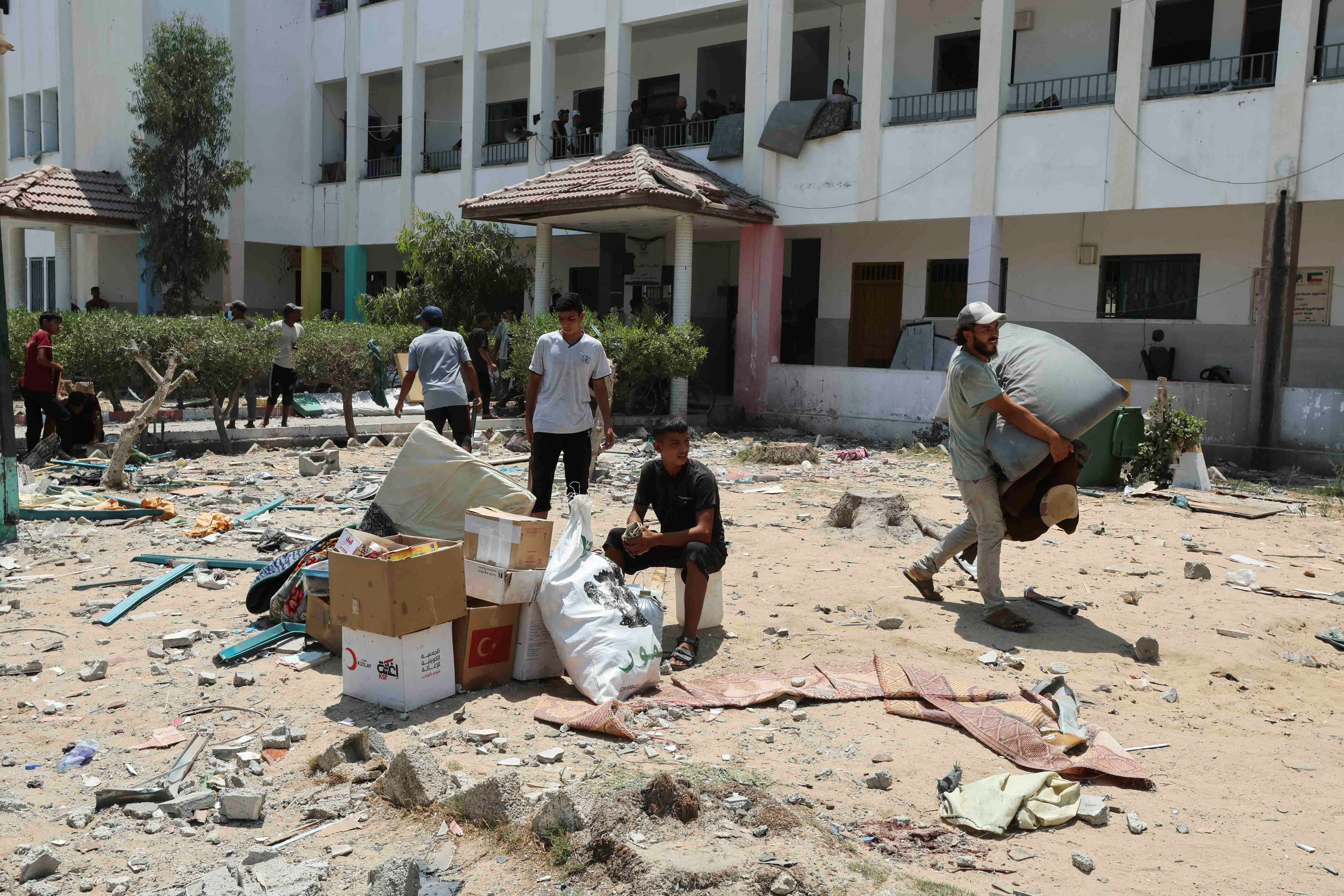 Palestinians leave the school after an airstrike killed at least 30 people