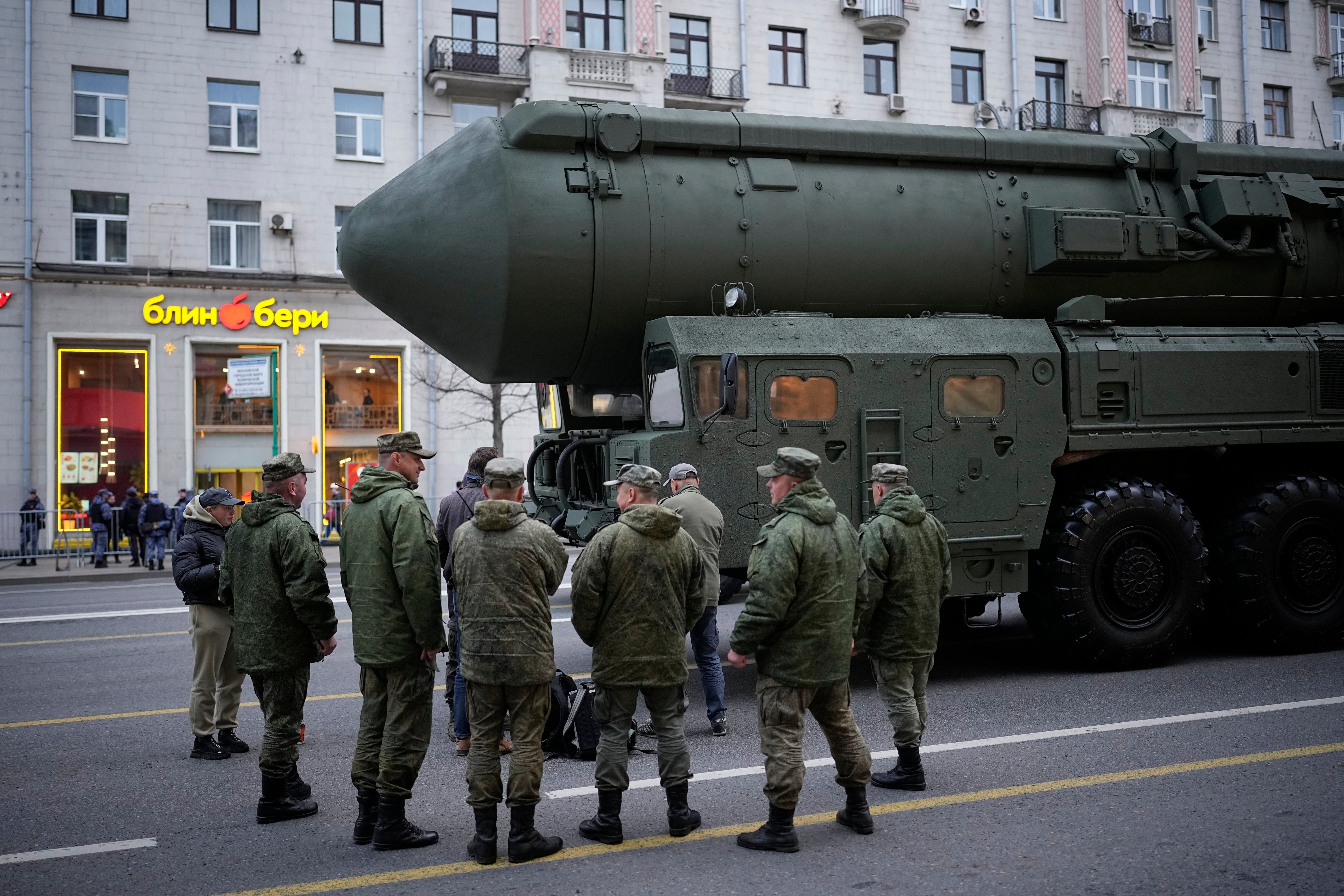 Soldiers stand next to a Russian RS-24 Yars ballistic missile parked along Tverskaya street