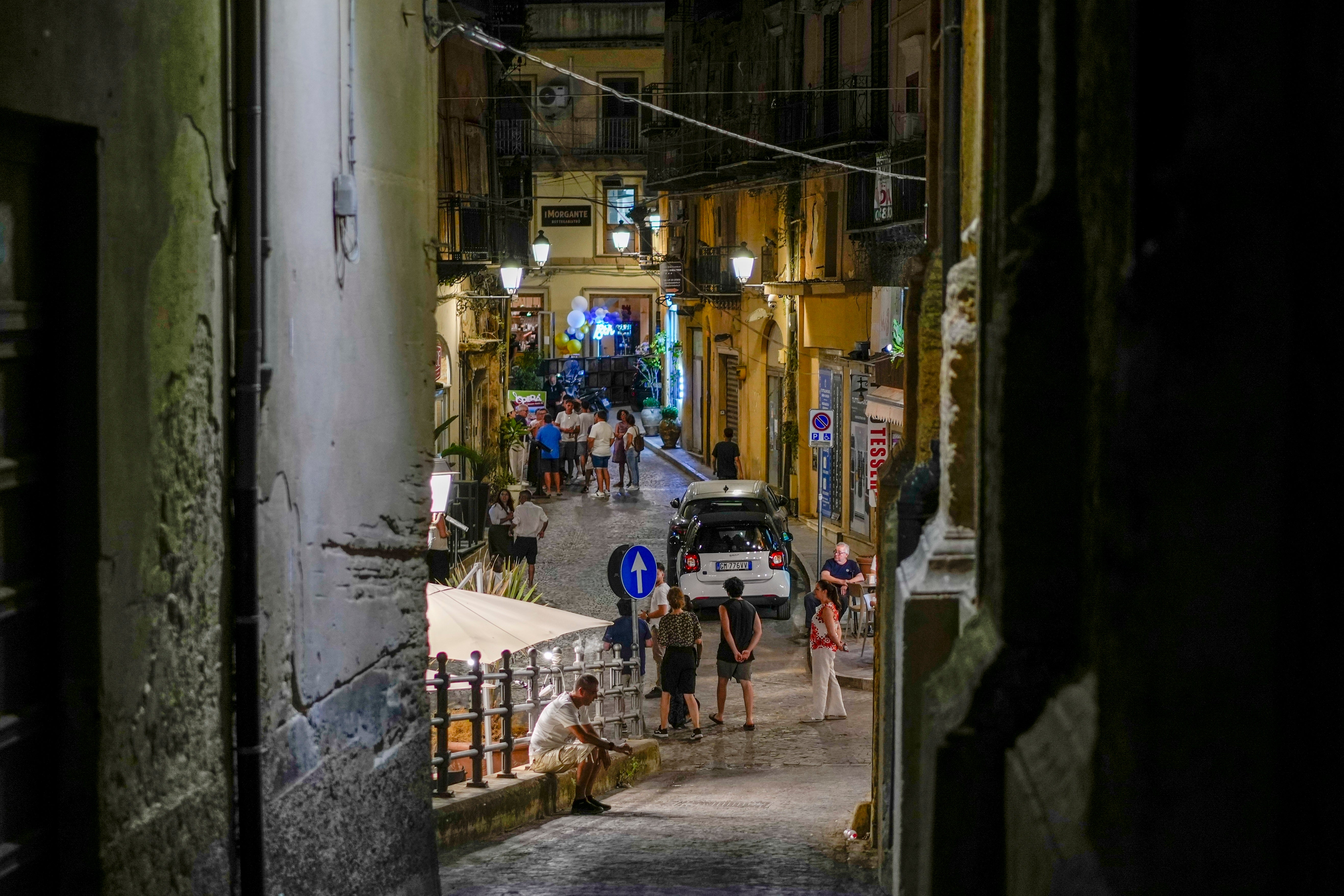 Tourists and residents hang out in a central street of Agrigento, southern Sicily, Italy, Wednesday, July 17, 2024