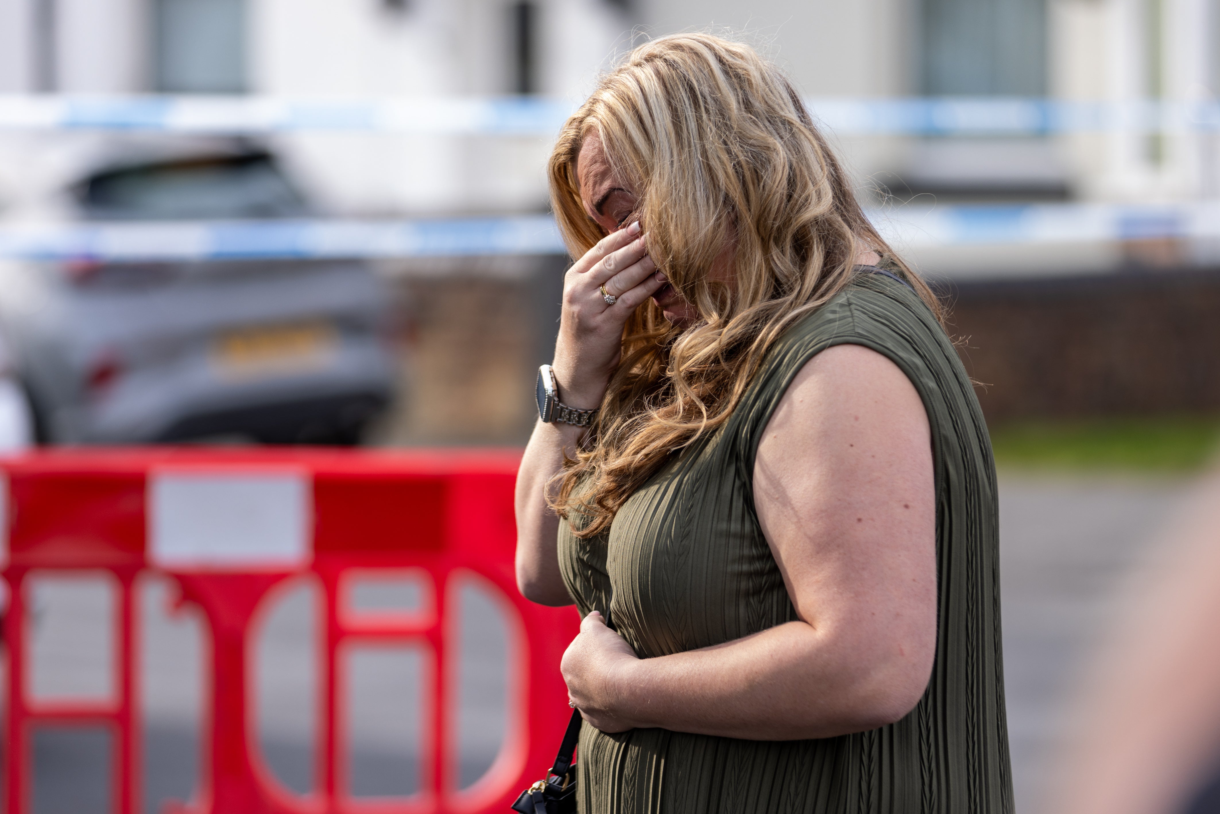 A person leaves flowers near the scene in Hart Street, Southport, where two children died