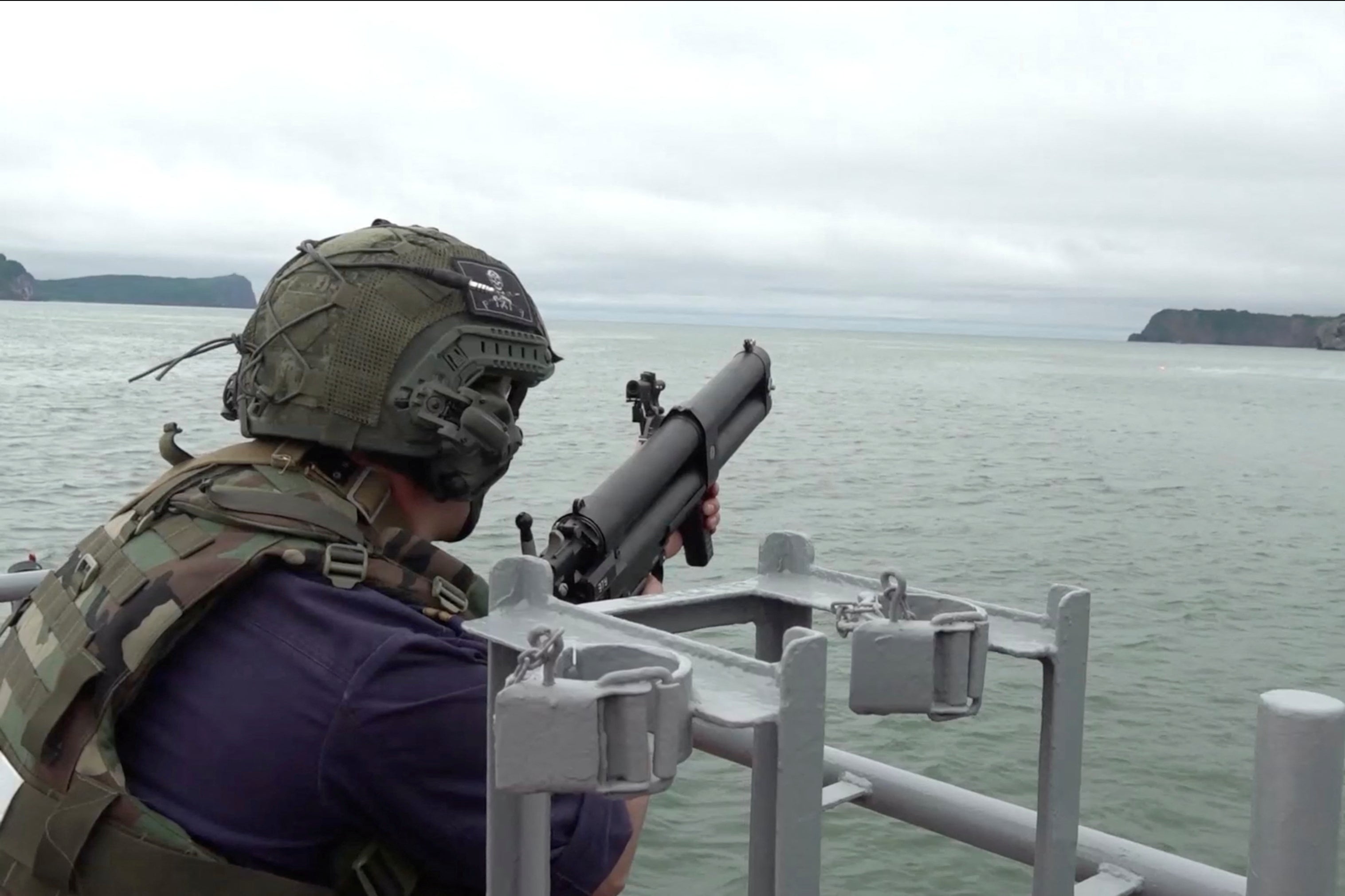 A Russian service member fires from aboard a warship during naval exercises at an undisclosed location