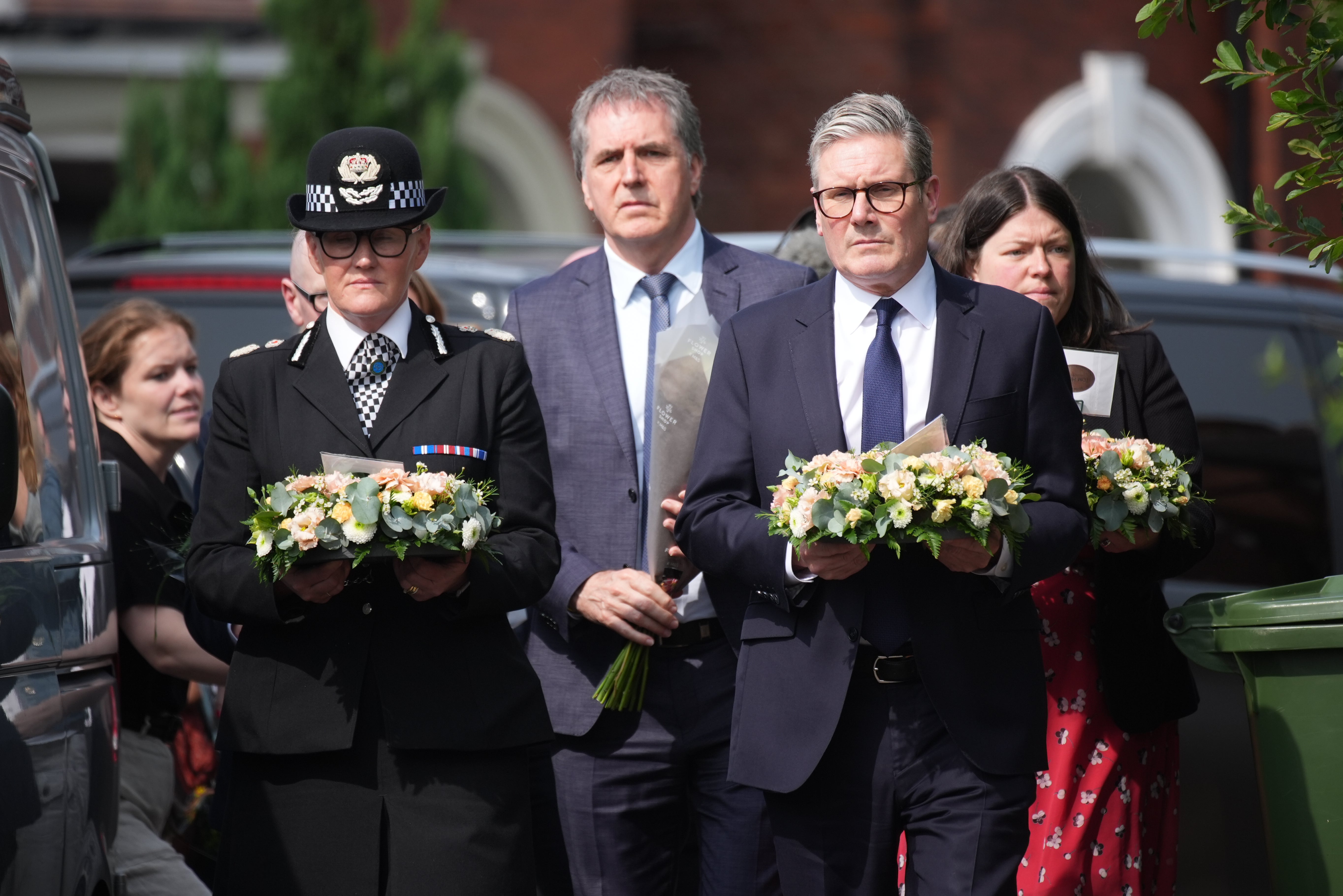 Keir Starmer arrives with a floral tribute to the child victims of Monday’s knife attack