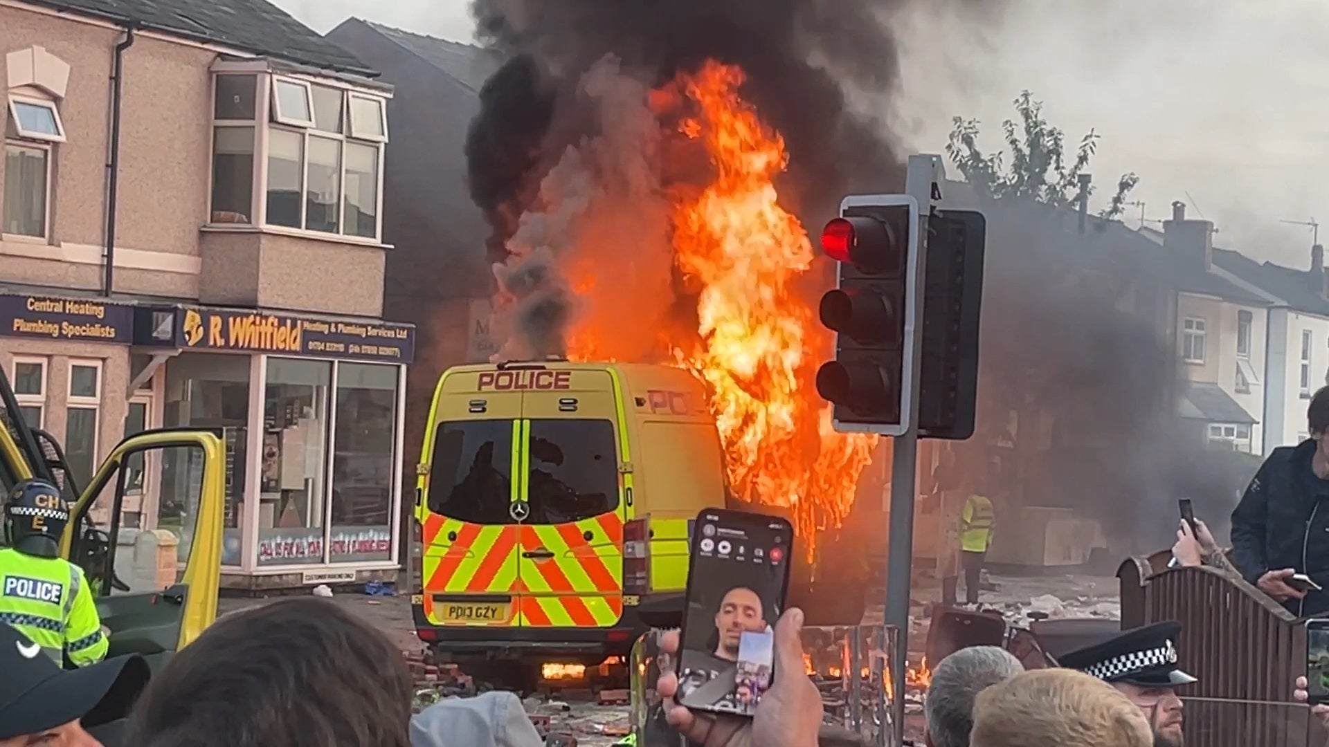 A police van set alight as trouble flares during a protest in Southport