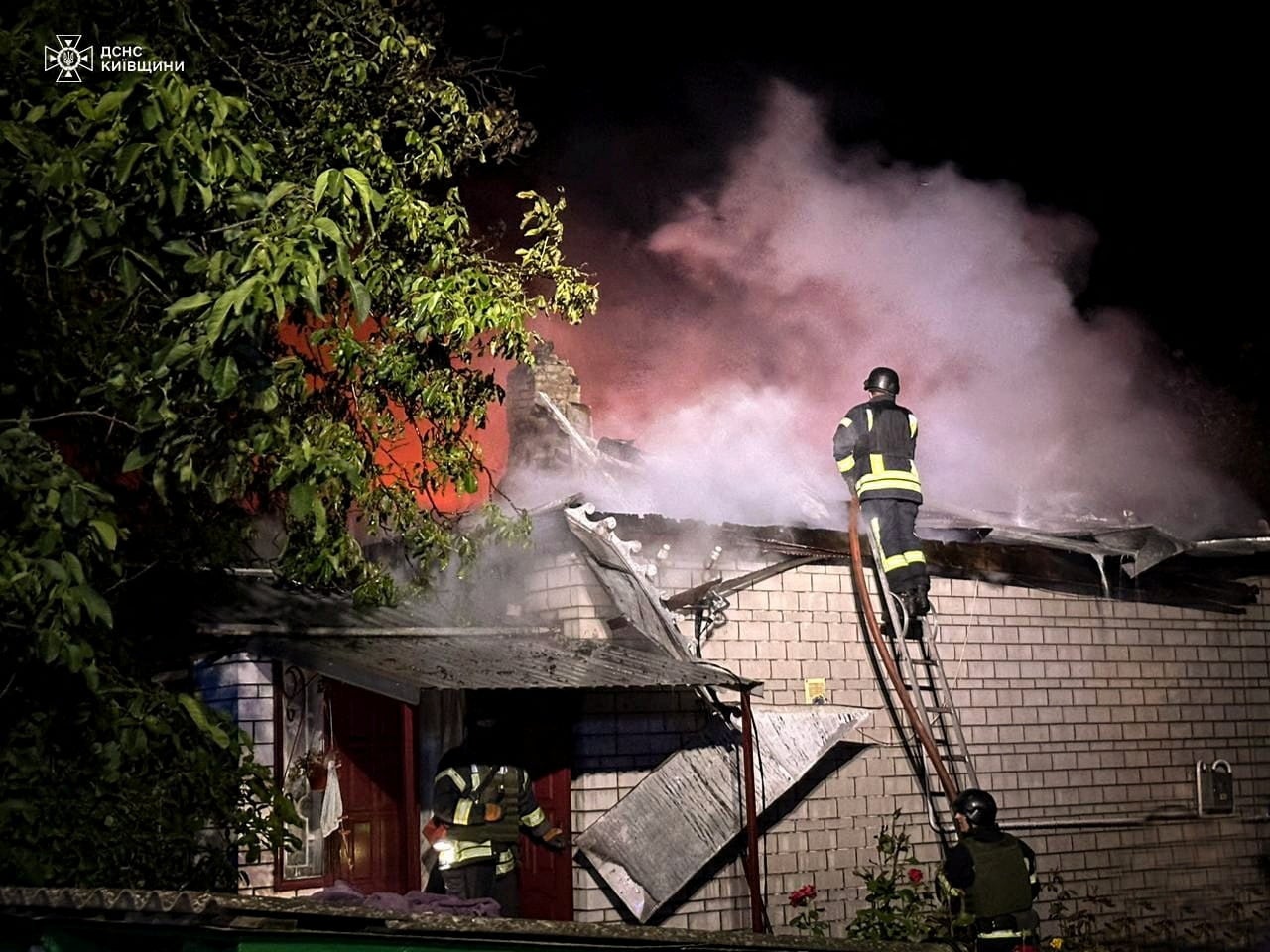 Firefighters work at a site of a residential building damaged during a Russian drone strike