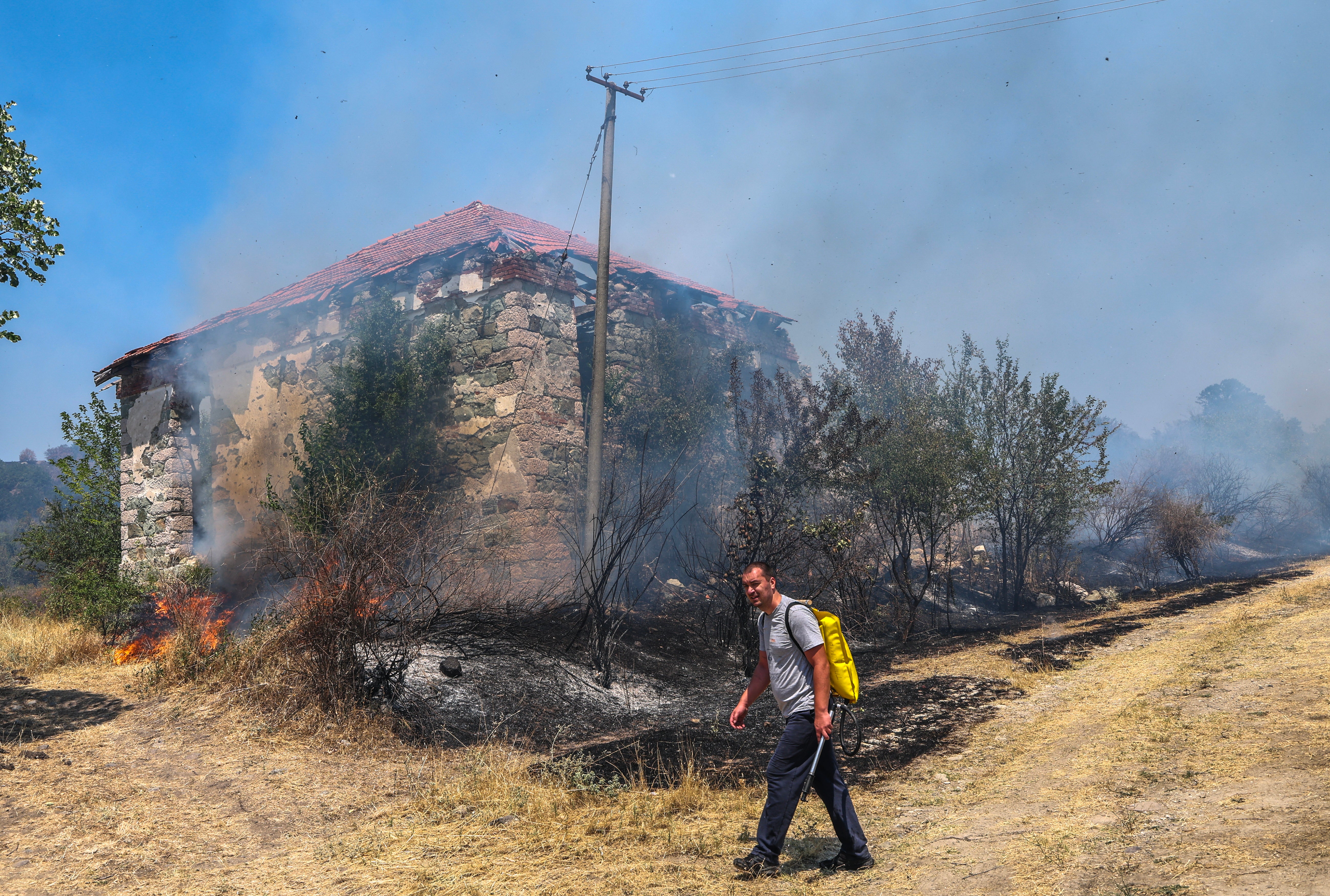 A volunteer walks past a burned area in the village of Kokosinjac, near Sveti Nikole, North Macedonia