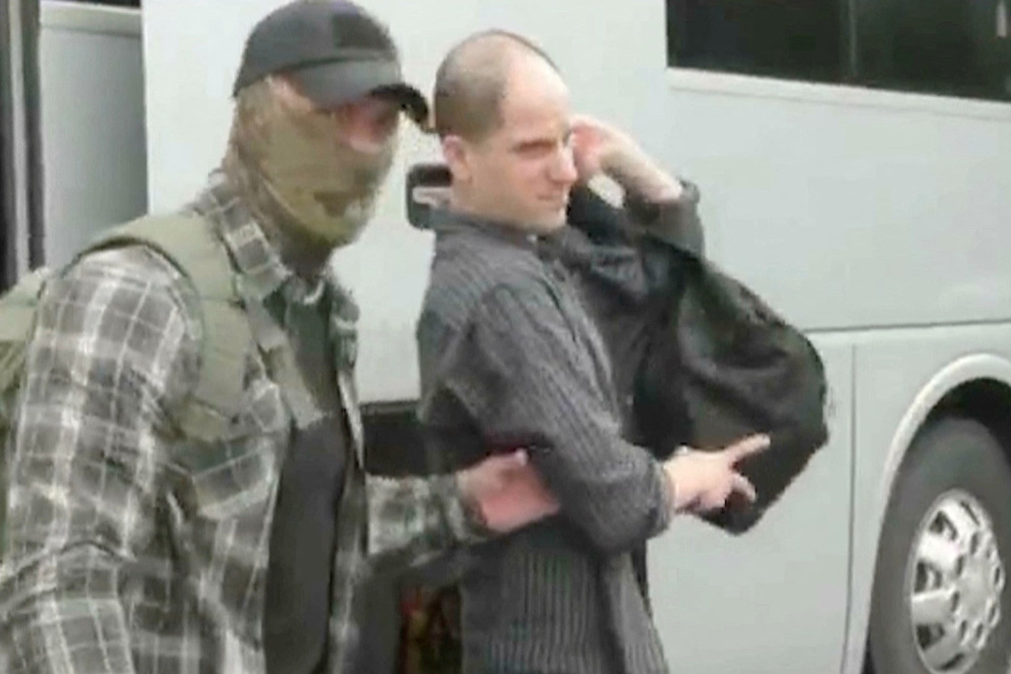 US journalist Evan Gershkovich is escorted by a federal security service officer before boarding a plane during a prisoner exchange between Russia with Western countries