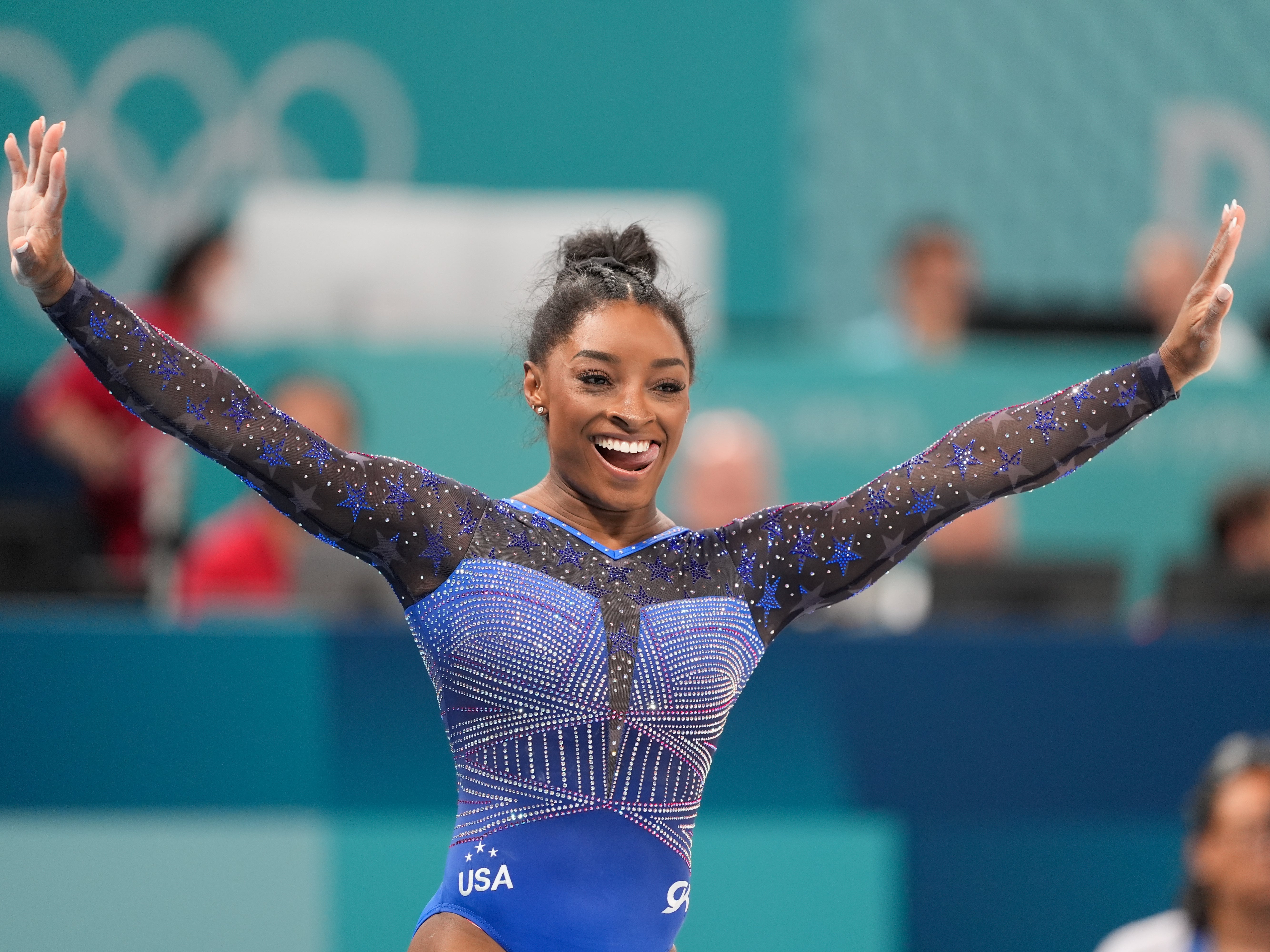 Simone Biles, of the United States, celebrates after performing on the balance beam