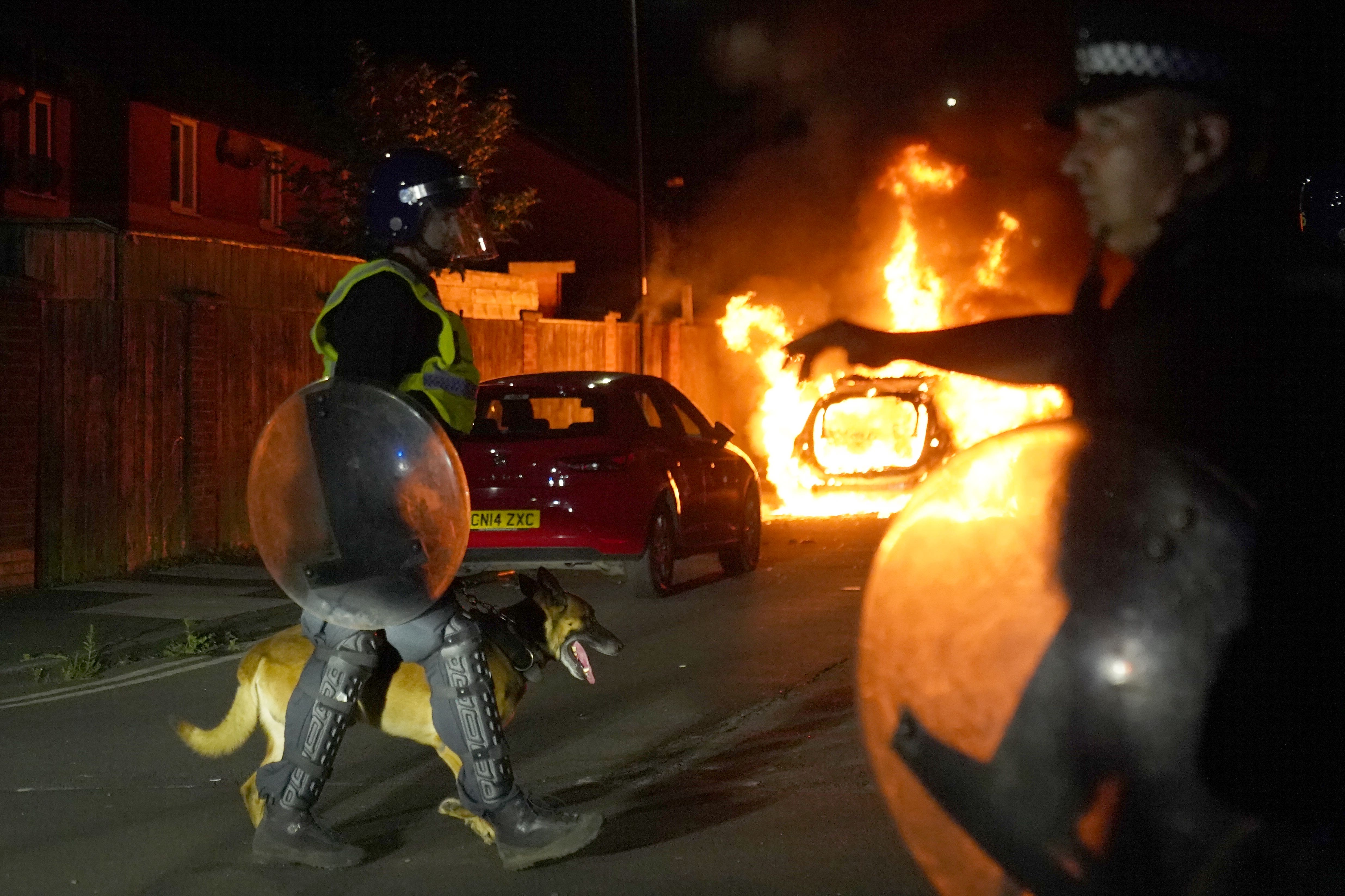 A police car burns (Owen Humphreys/PA)