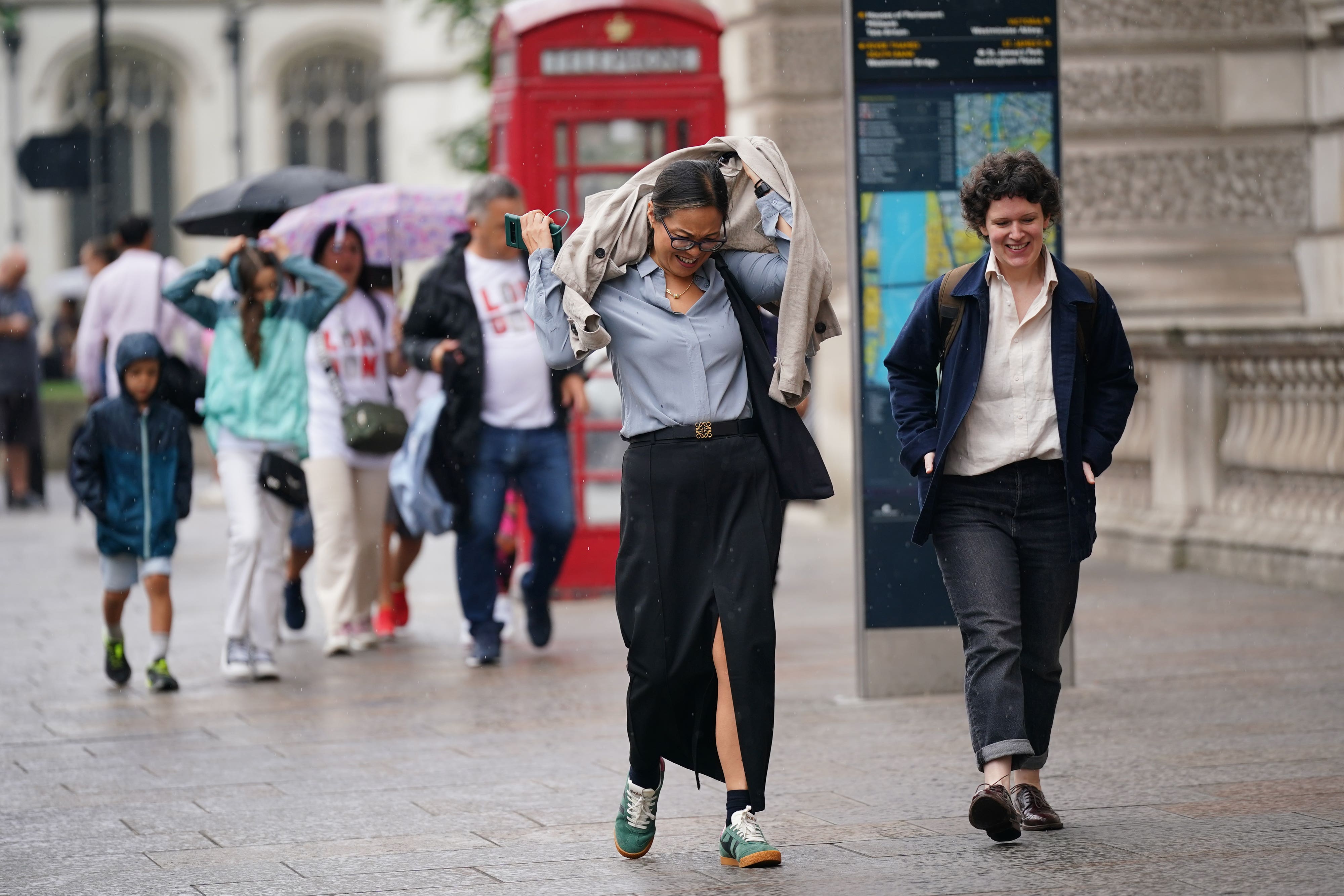 People walking in a rain shower on Whitehall (Yui Mok/PA)