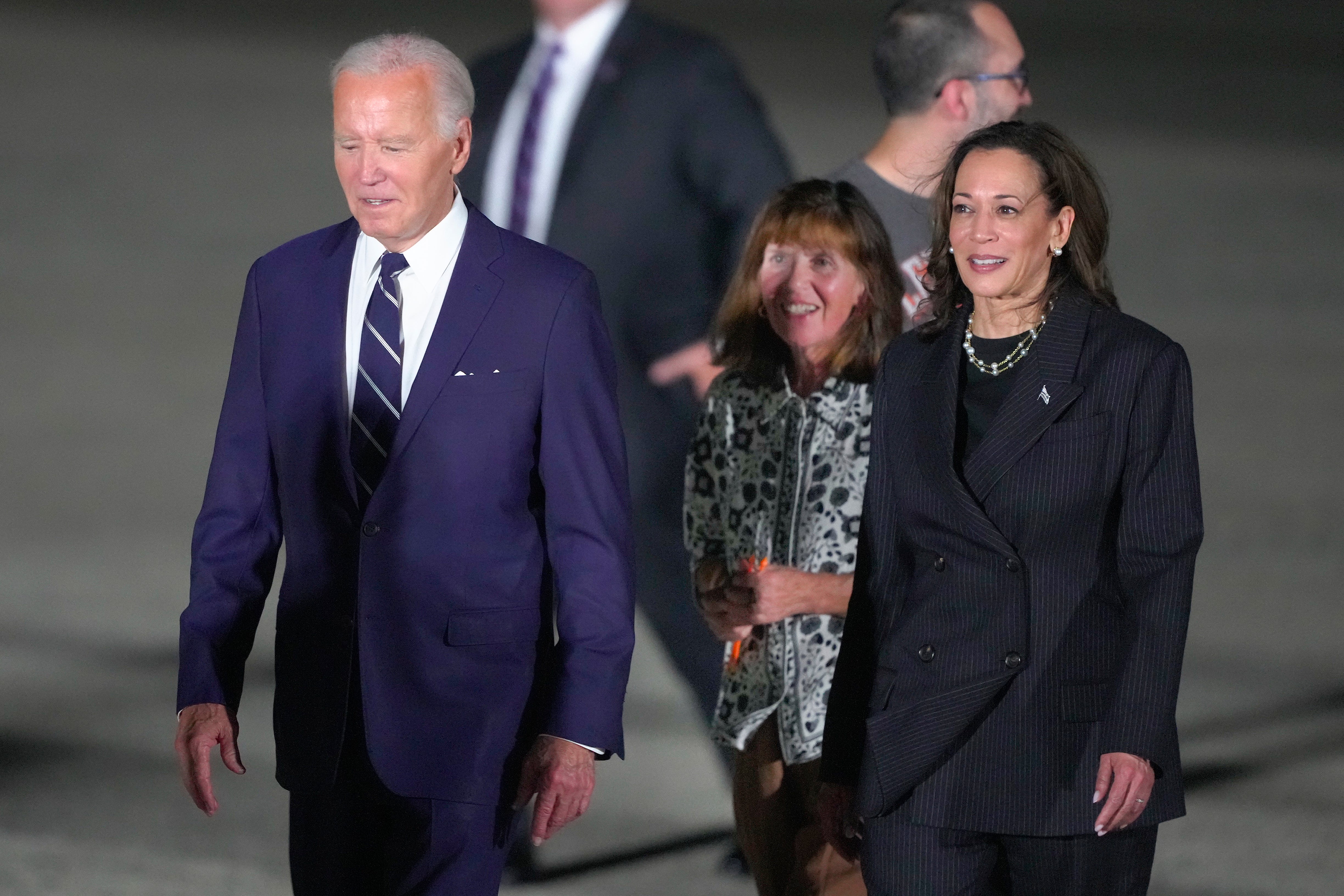 President Joe Biden, left, and vice president Kamala Harris, right, walking with Ella Milman, center, mother of reporter Evan Gershkovich, at Andrews Air Force Base