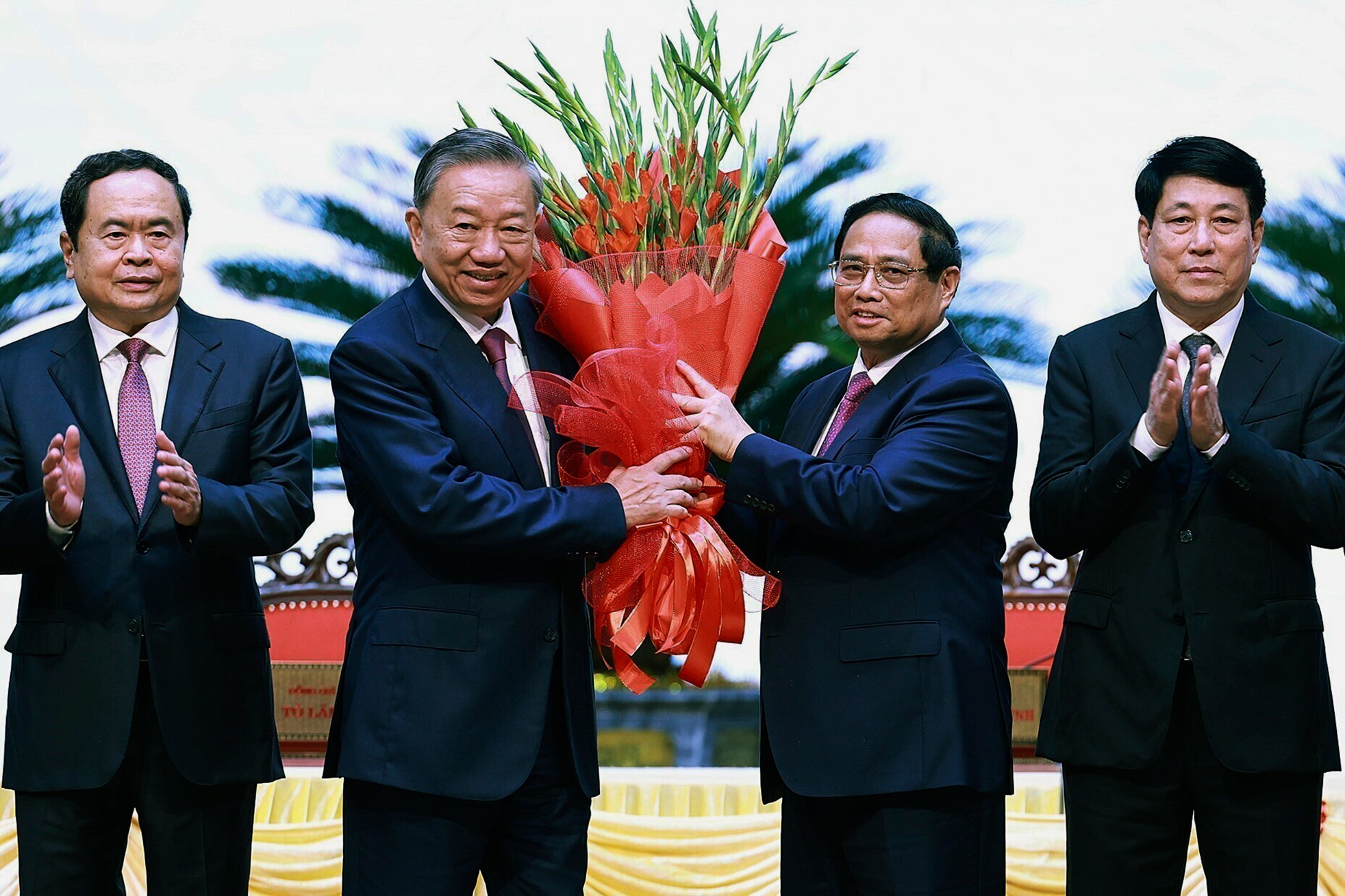 Vietnam PM Pham Minh Chinh, right, congratulates president To Lam with flowers as he was confirmed the new Community Party Chief,