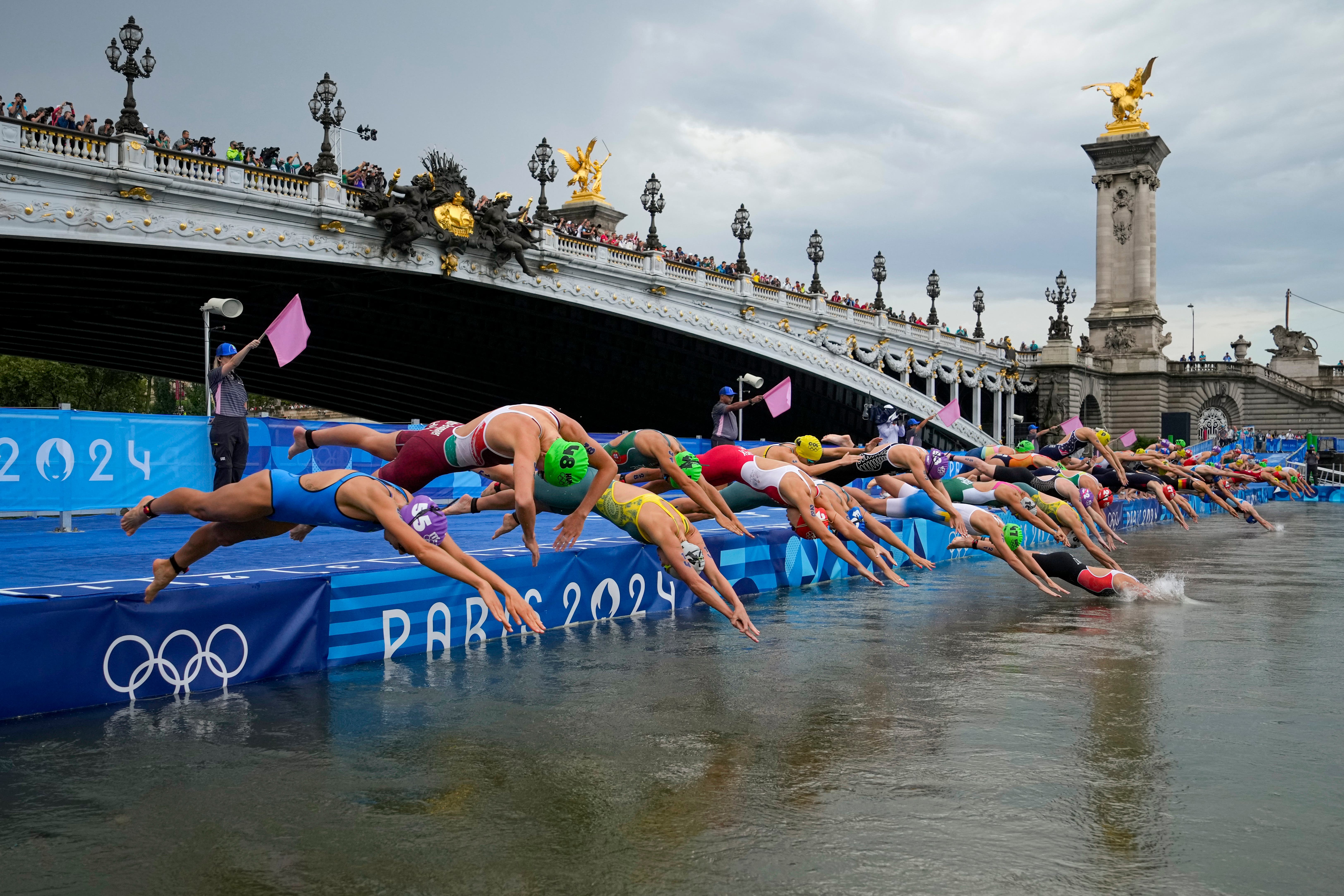 Athletes dive into the water for the start of the women’s triathlon (Vadim Ghirda/AP)