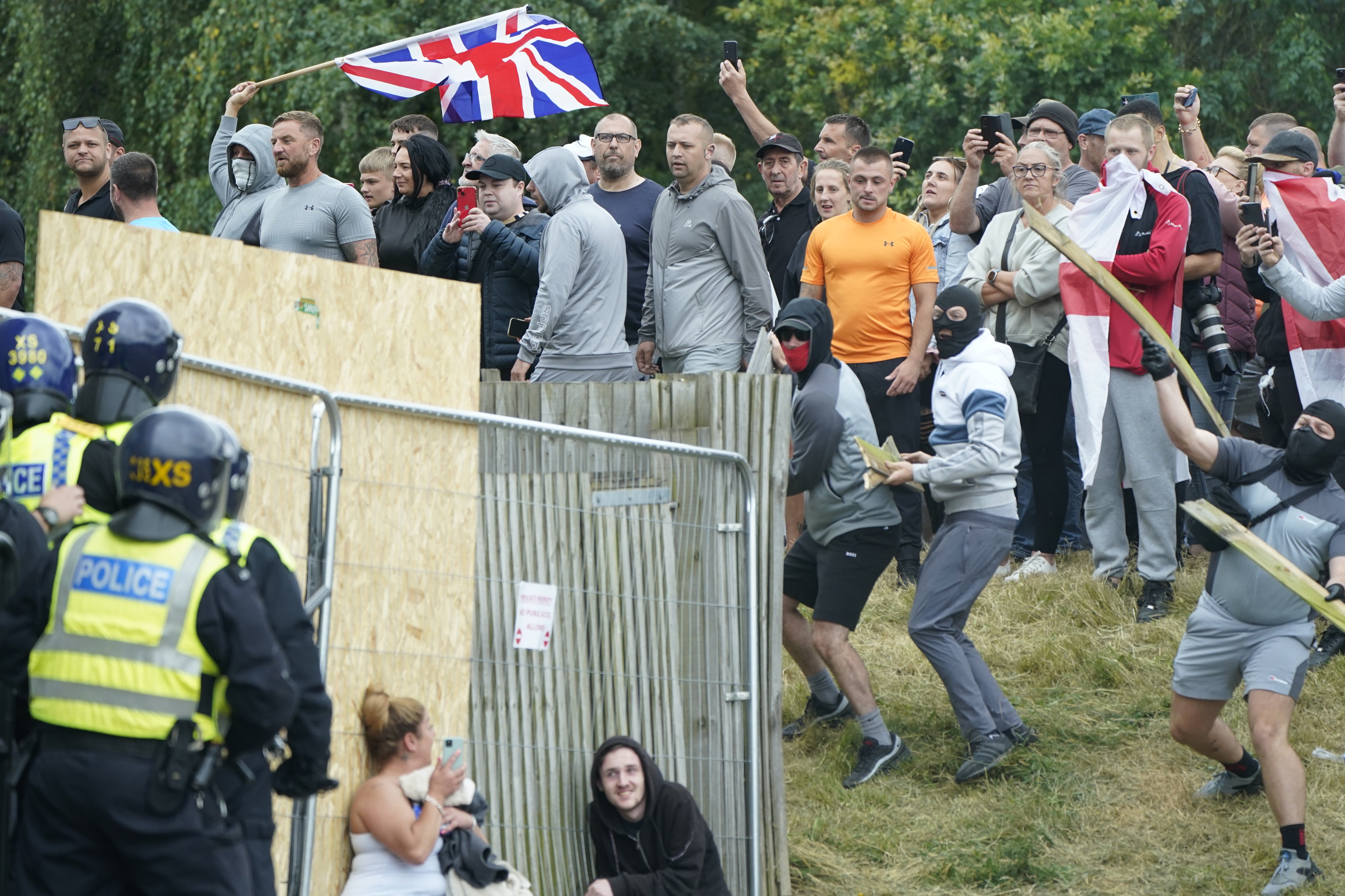 A woman takes cover as rioters throw rocks in Rotherham on Sunday