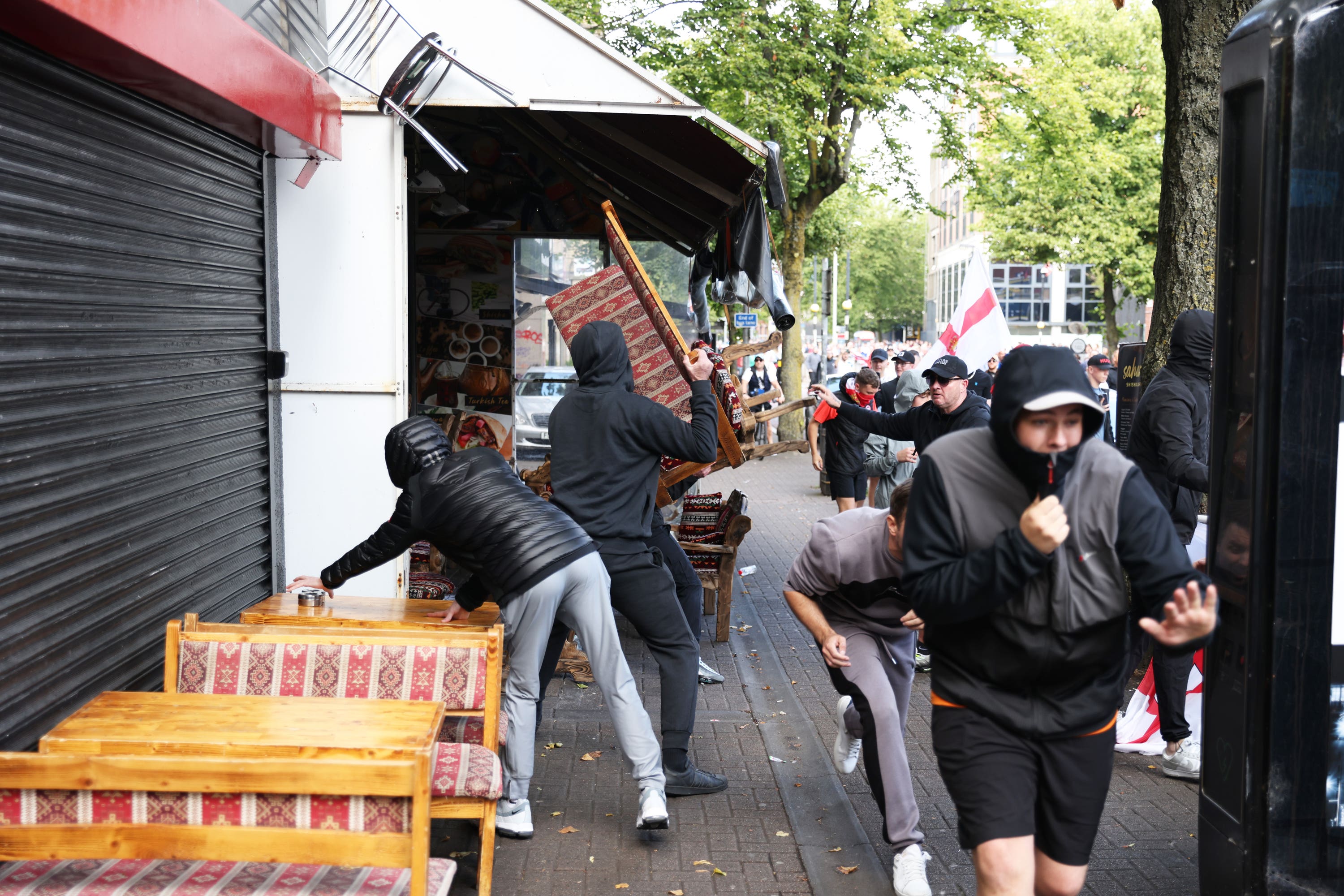 People taking part in an anti-Islamic protest attack a cafe in Botanic Avenue in Belfast (Peter Morrison/PA)