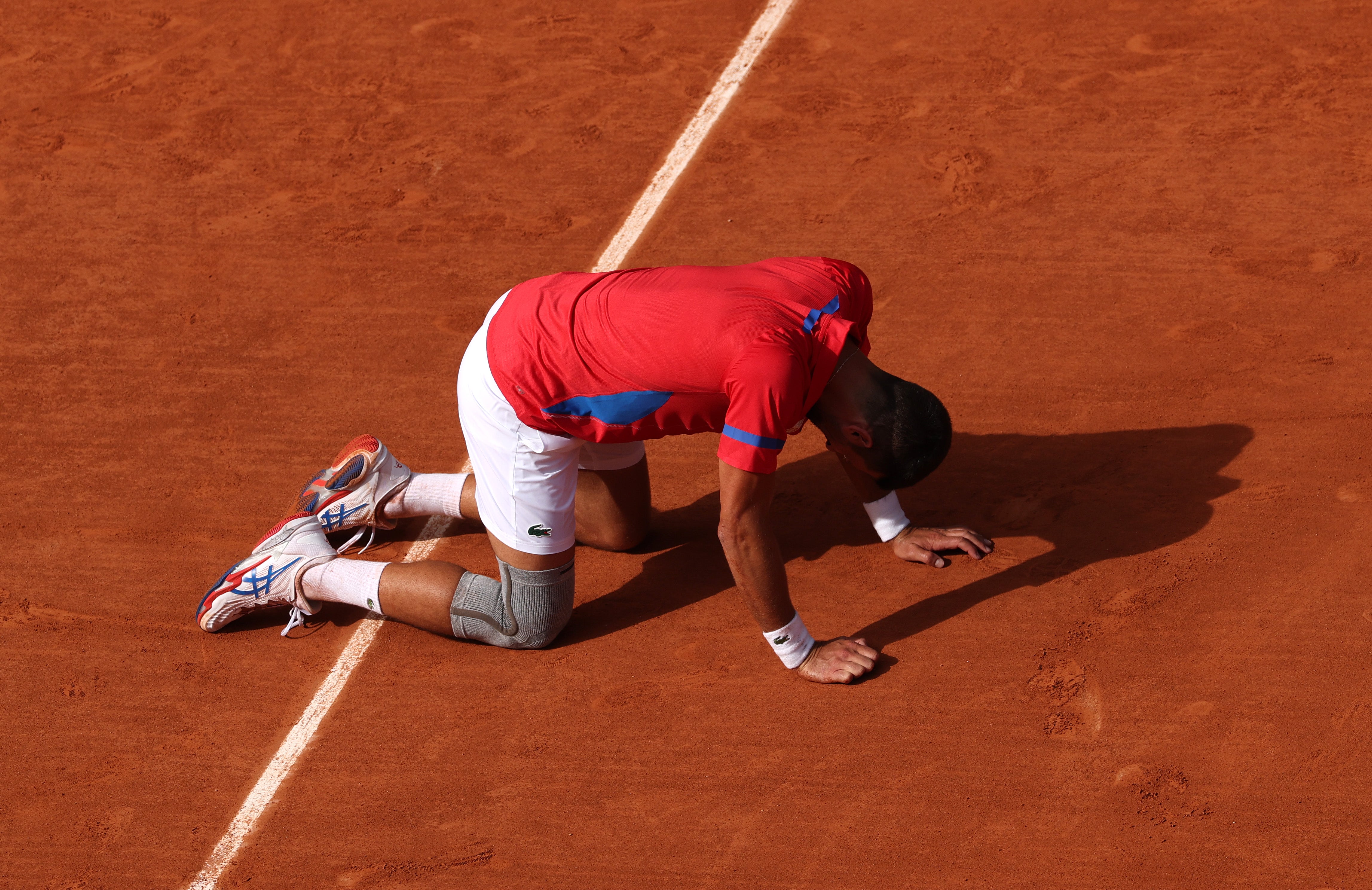 Djokovic finishes an epic contest on all fours