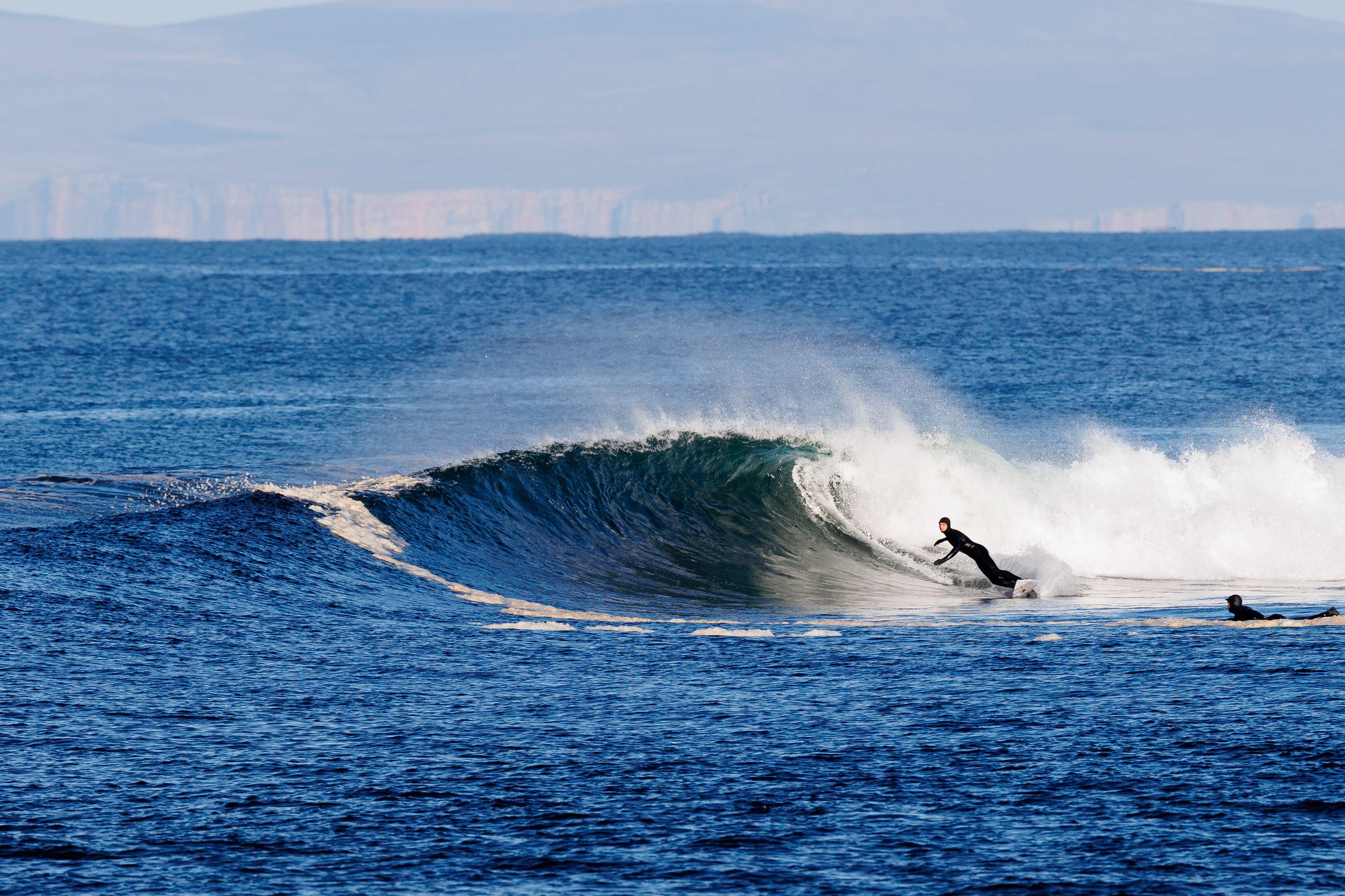 A surfer riding a wave at Thurso East