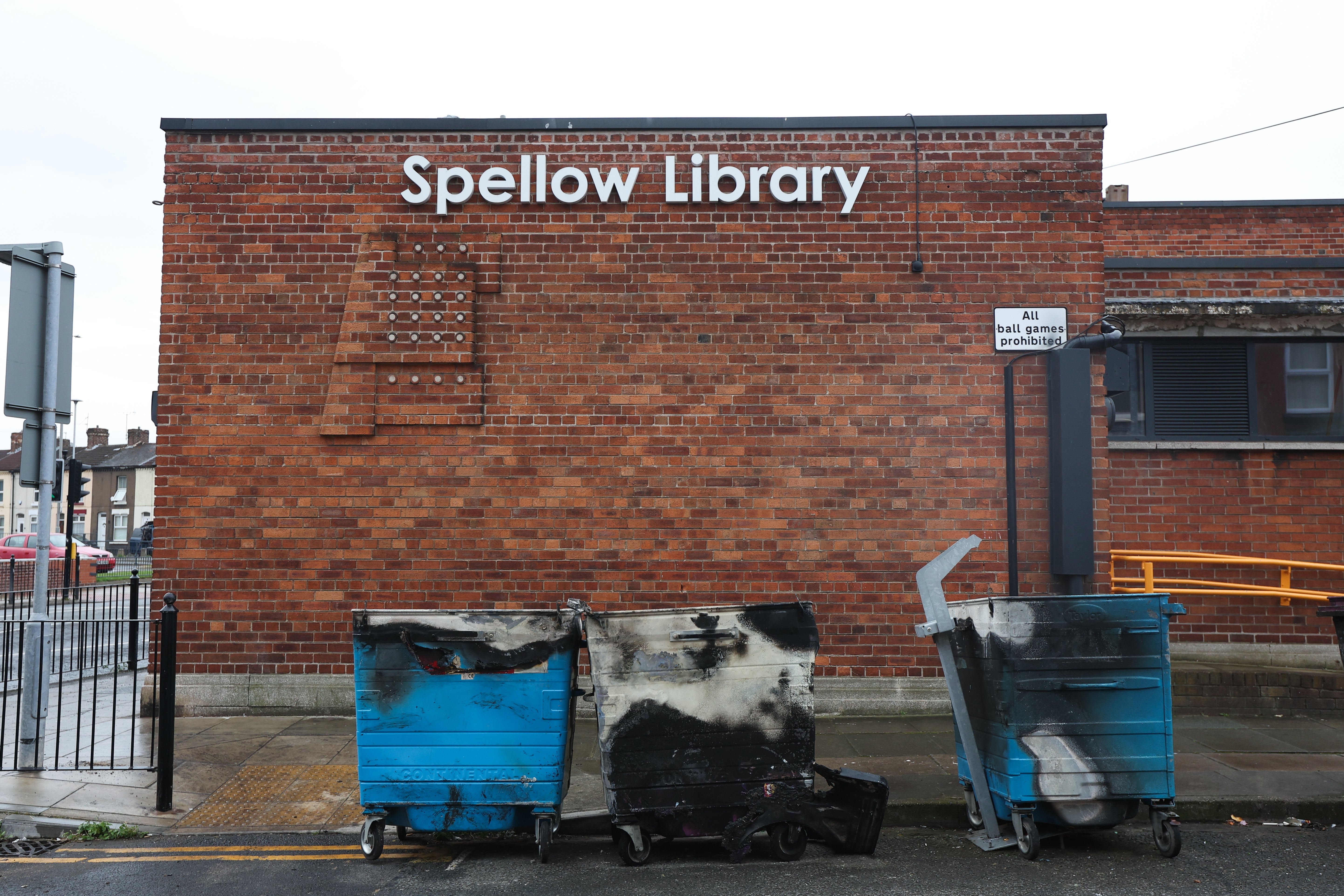 Charred wheelie bins outside the Spellow Hub community library after a night of violent disorder in Liverpool