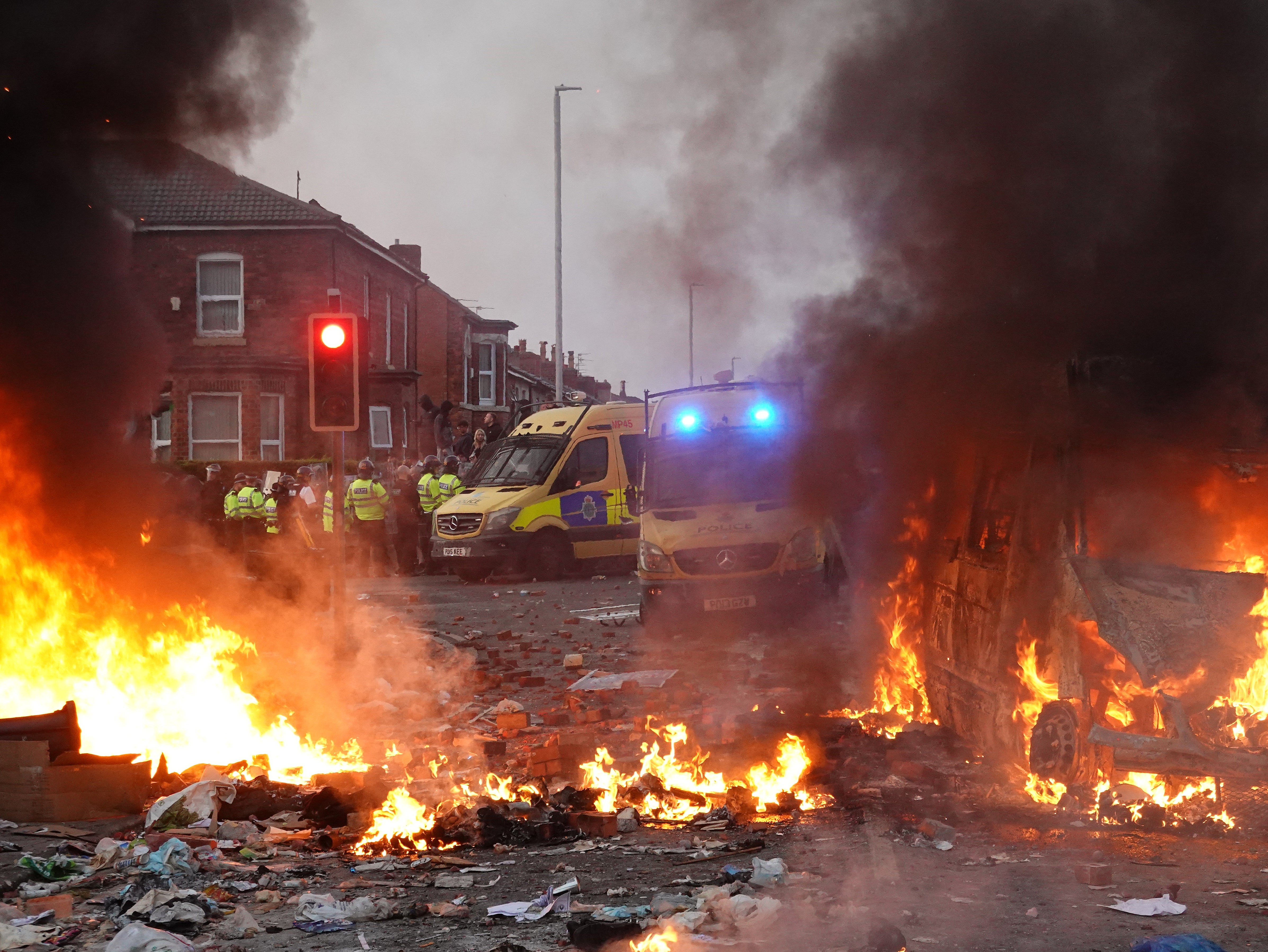 Police hold back rioters near a burning police vehicle in Southport during last week’s disturbances