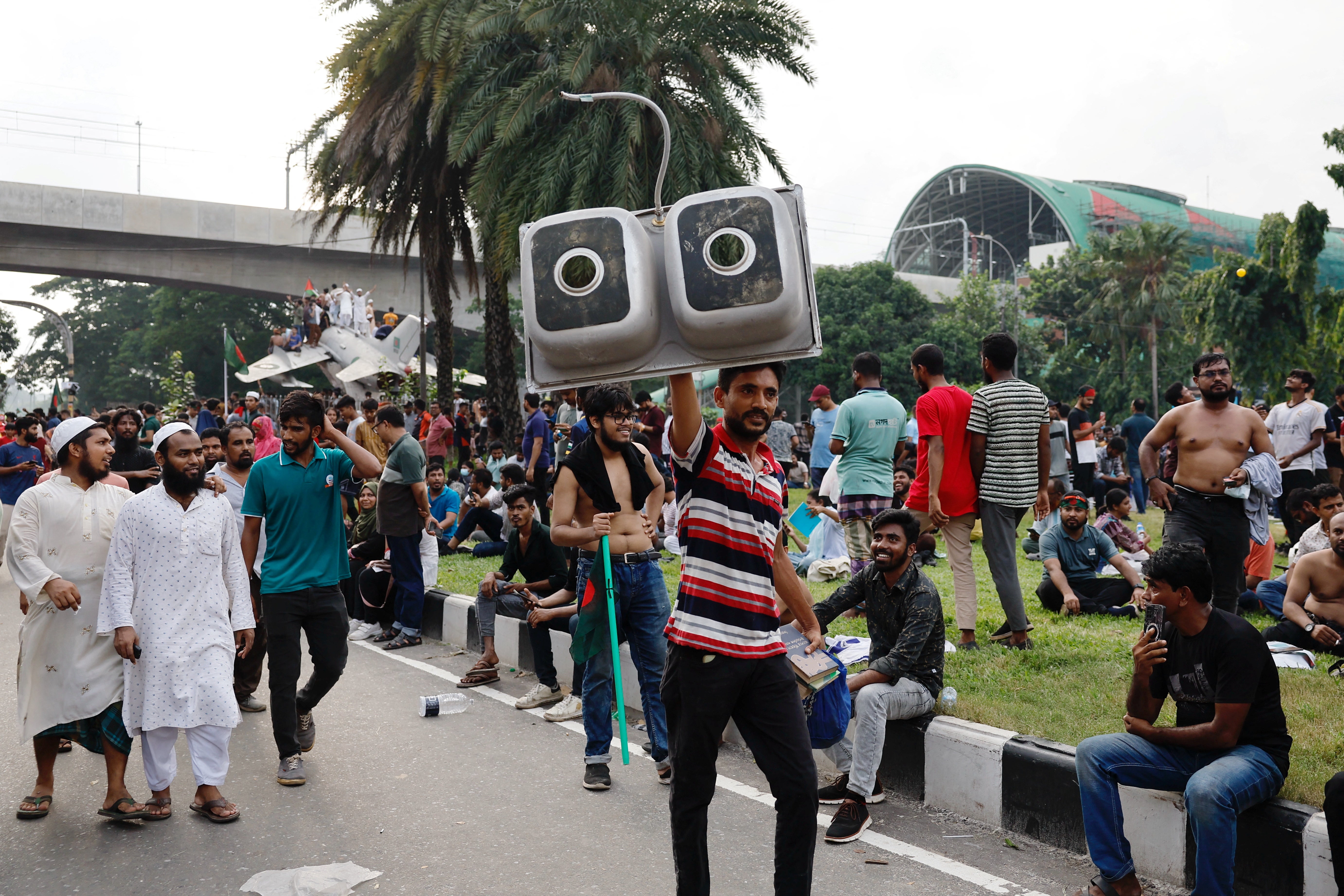 A man carries a looted item from the Ganabhaban, the Prime Minister's residence, after the resignation of PM Sheikh Hasina in Dhaka, Bangladesh, 5 Aug 2024