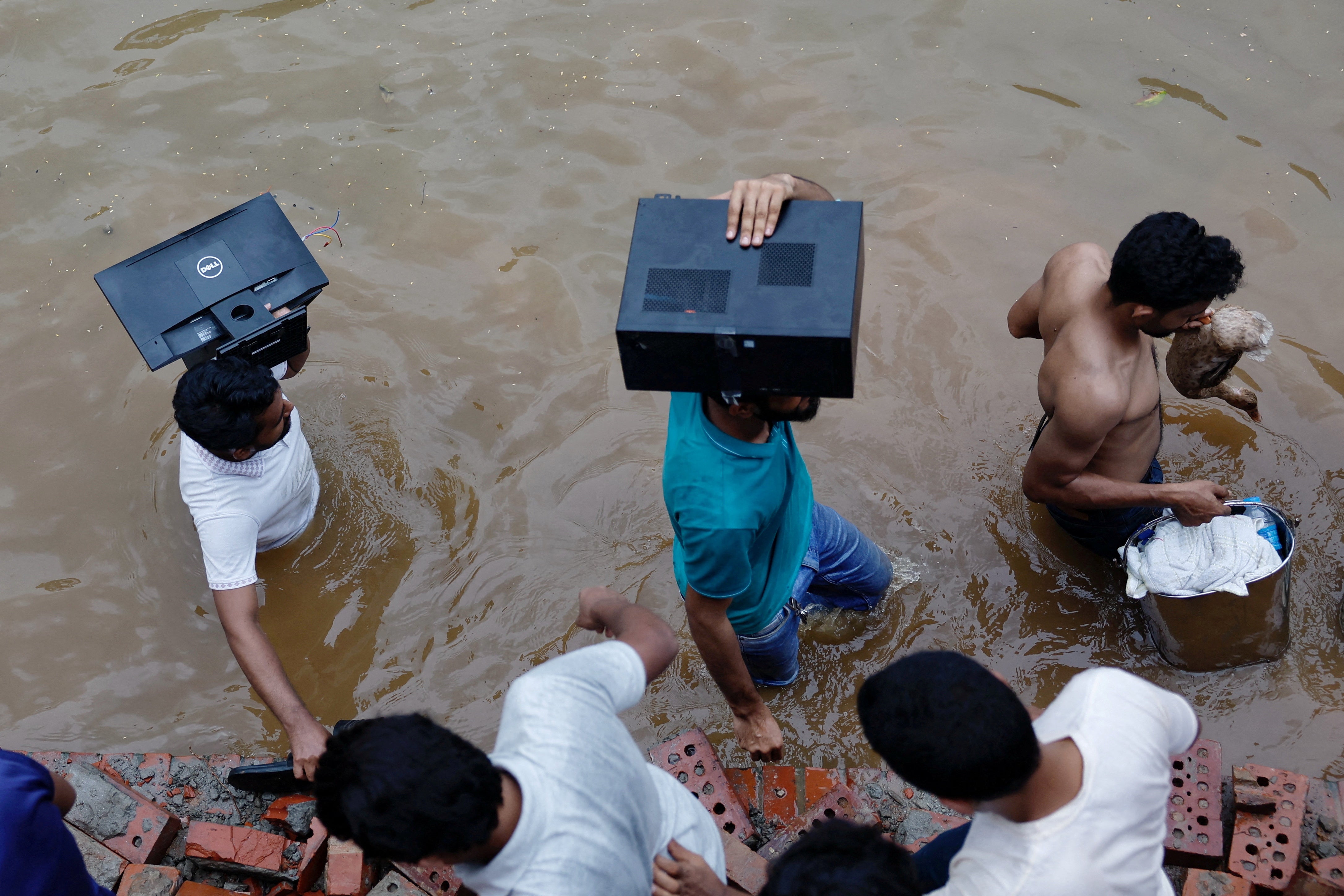 People loot a monitor, a computer and a duck from the Ganabhaban, the prime minister’s residence, after the resignation of PM Sheikh Hasina in Dhaka, Bangladesh