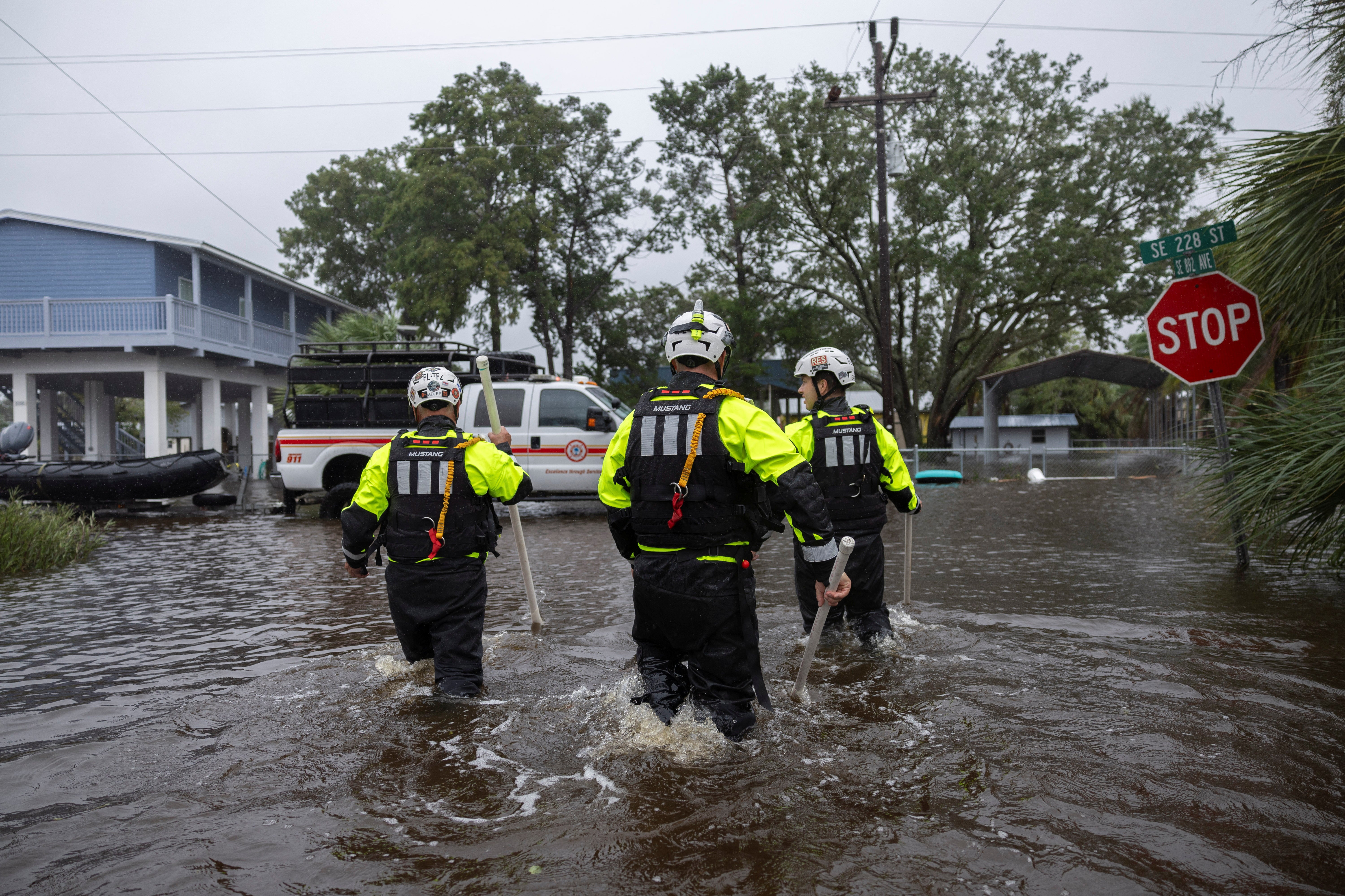 Miami Search and Rescue Fire Department personnel search for people in flooded houses