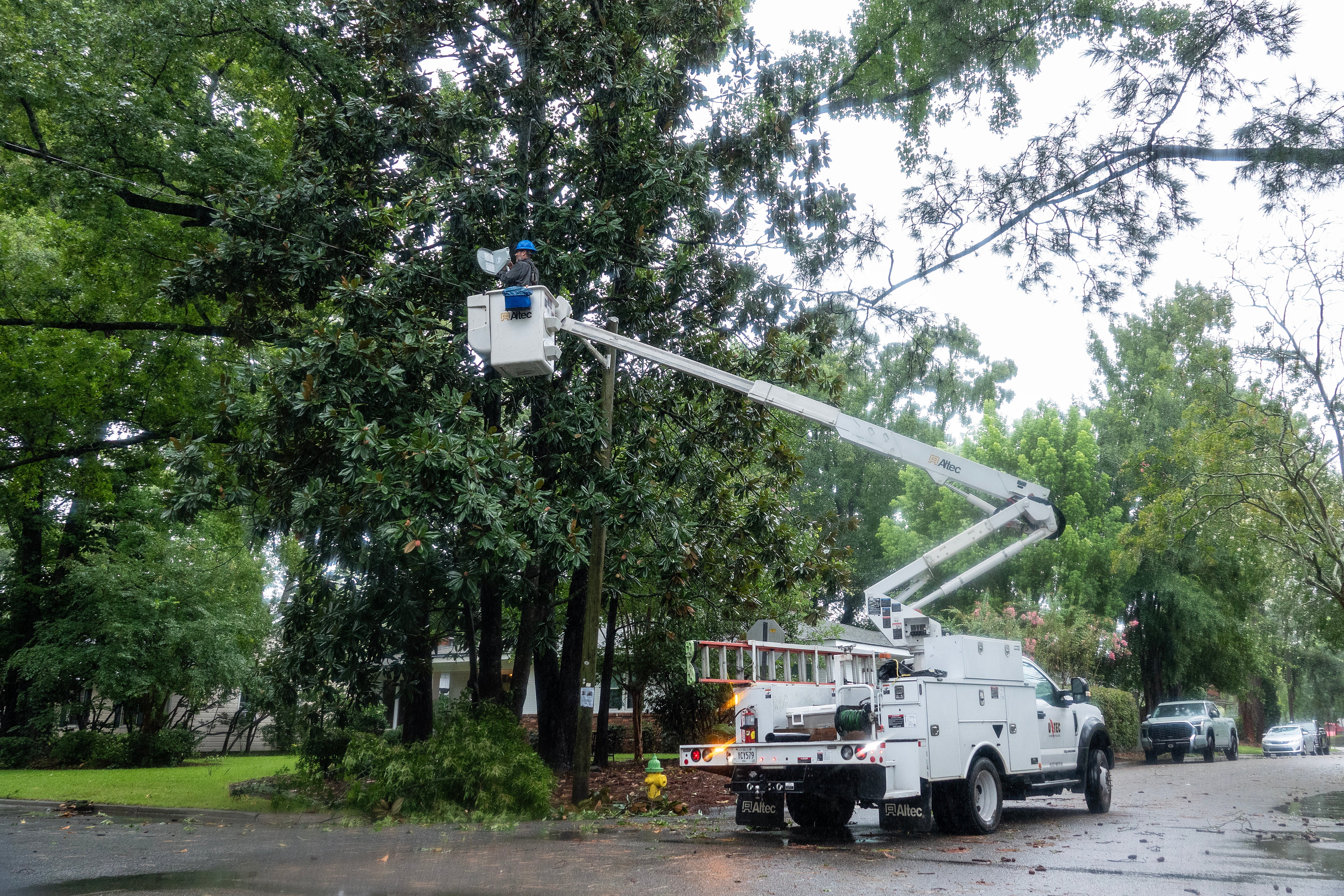 An electrical worker fixes a street lamp in Savannah, Georgia on Tuesday as Debby knocks out power to more than 17,000 people in the state