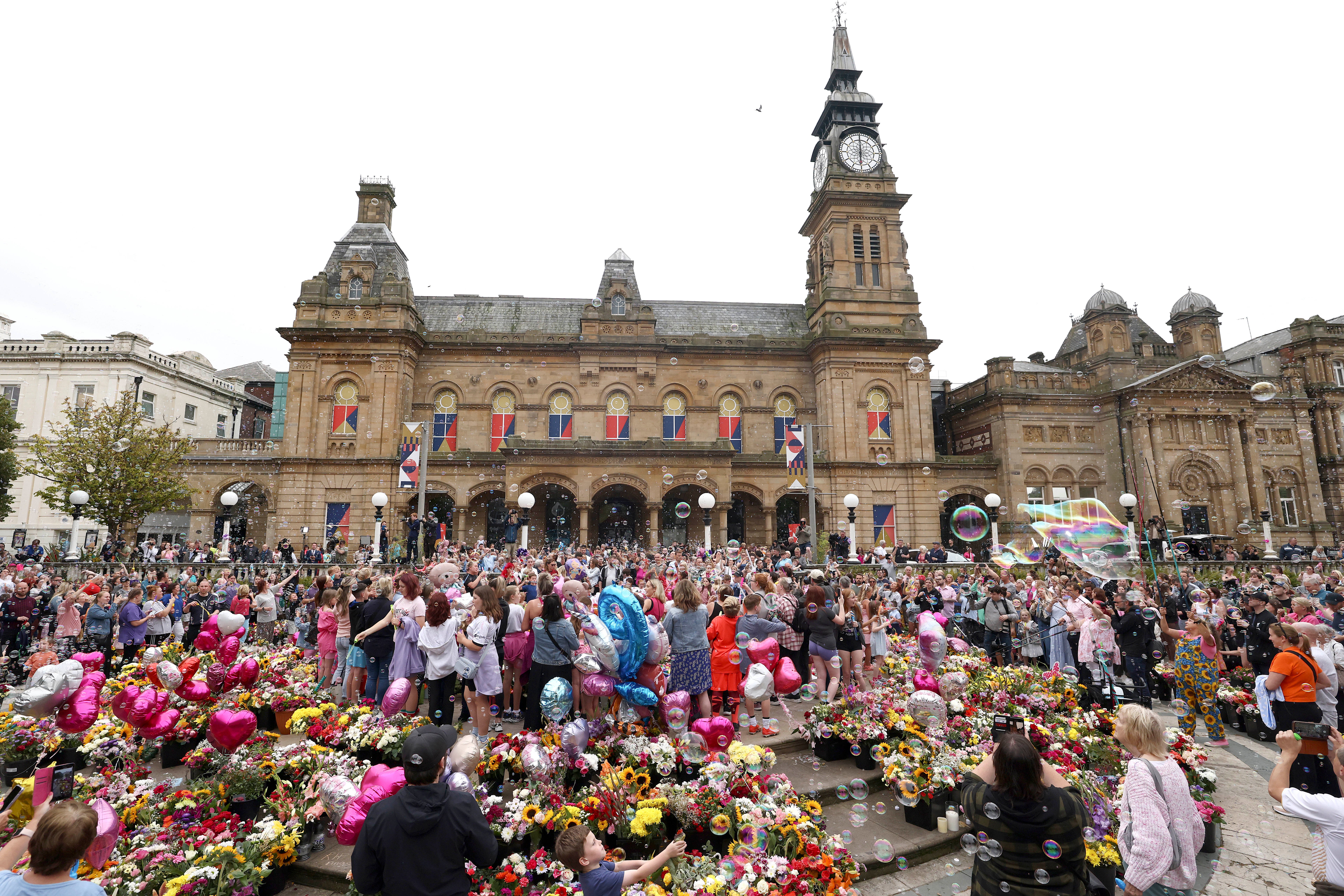 Members of the public form bubbles outside the Town Hall during a vigil to remember the victims of the stabbing attack last Monday in Southport