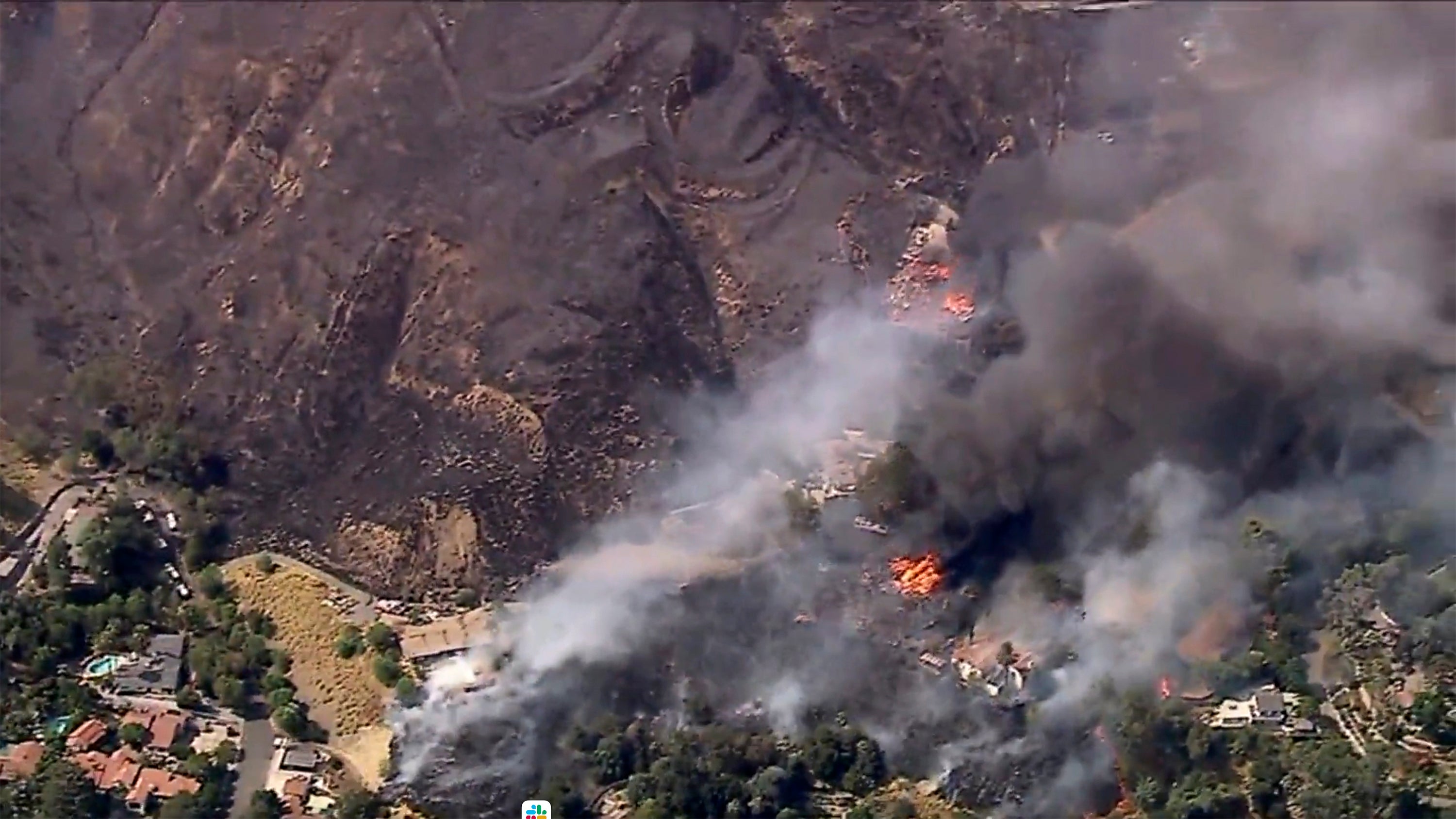 Several homes burn as a fast-moving wildfire torched a California hillside