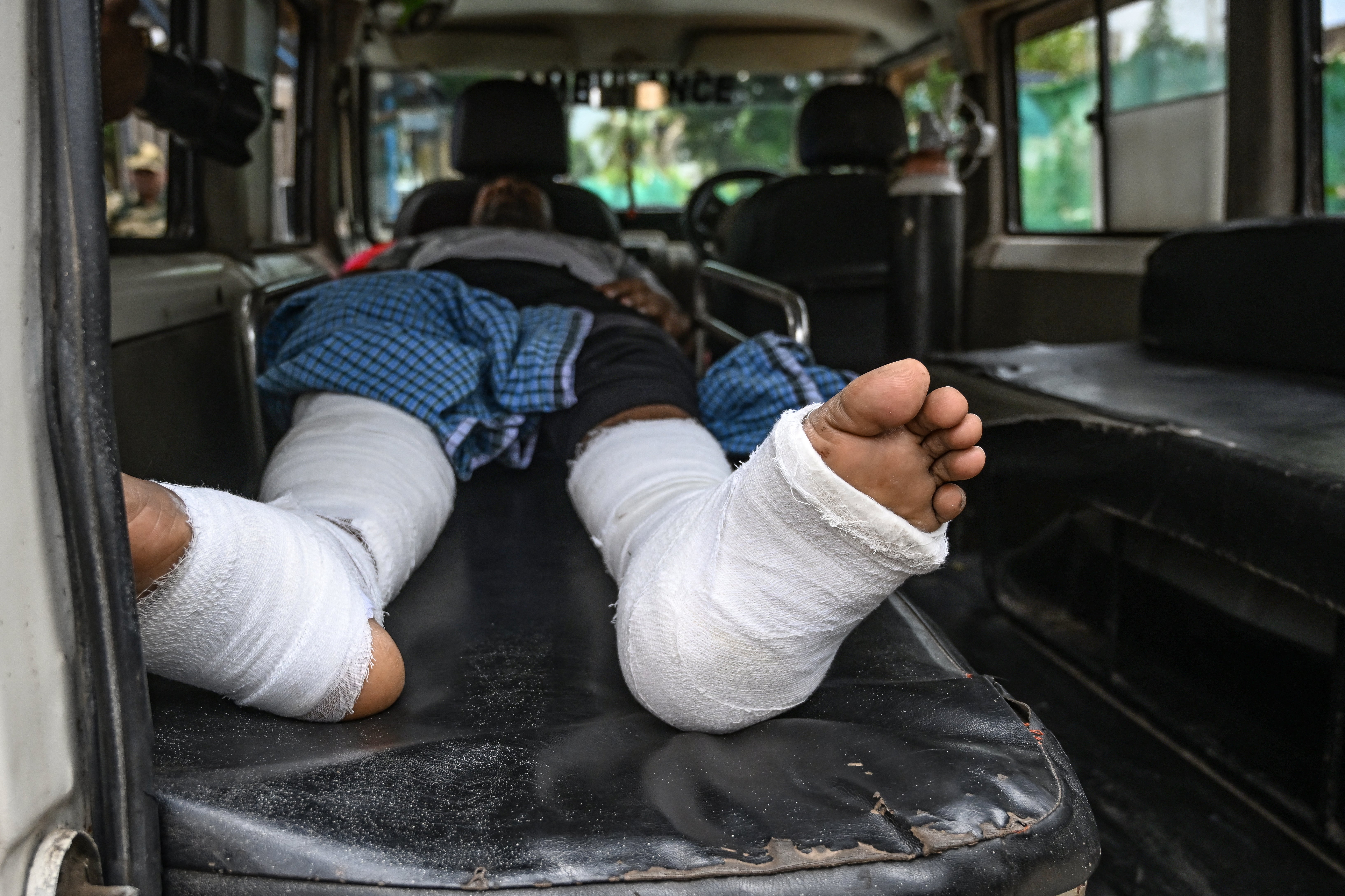 Shahid Ali, an Indian citizen injured during violence in Bangladesh, lies in an ambulance