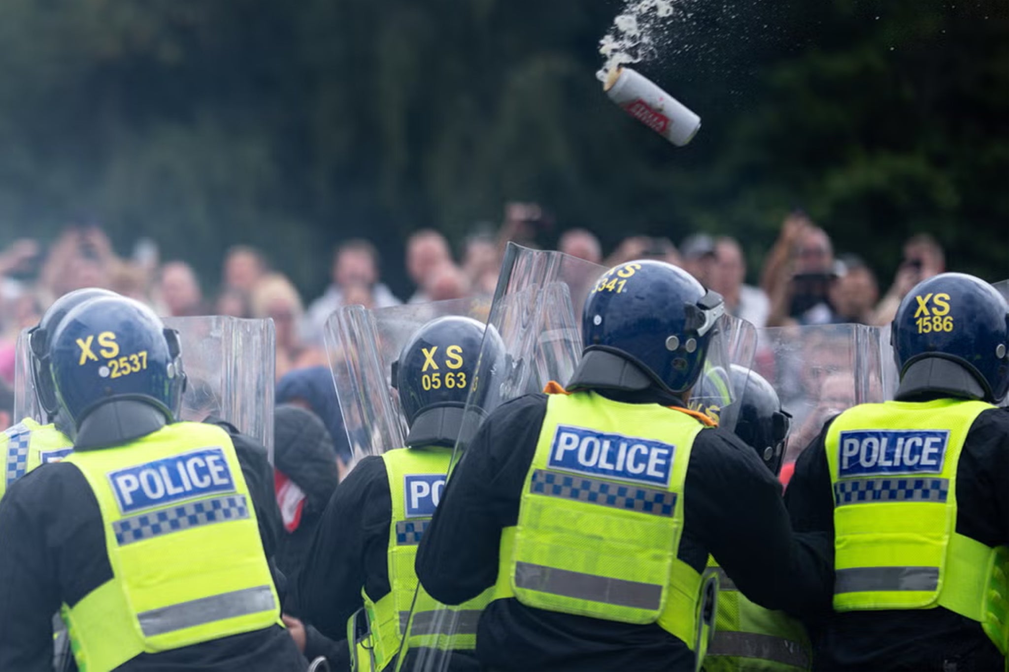 Riot police officers push back anti-immigration protesters