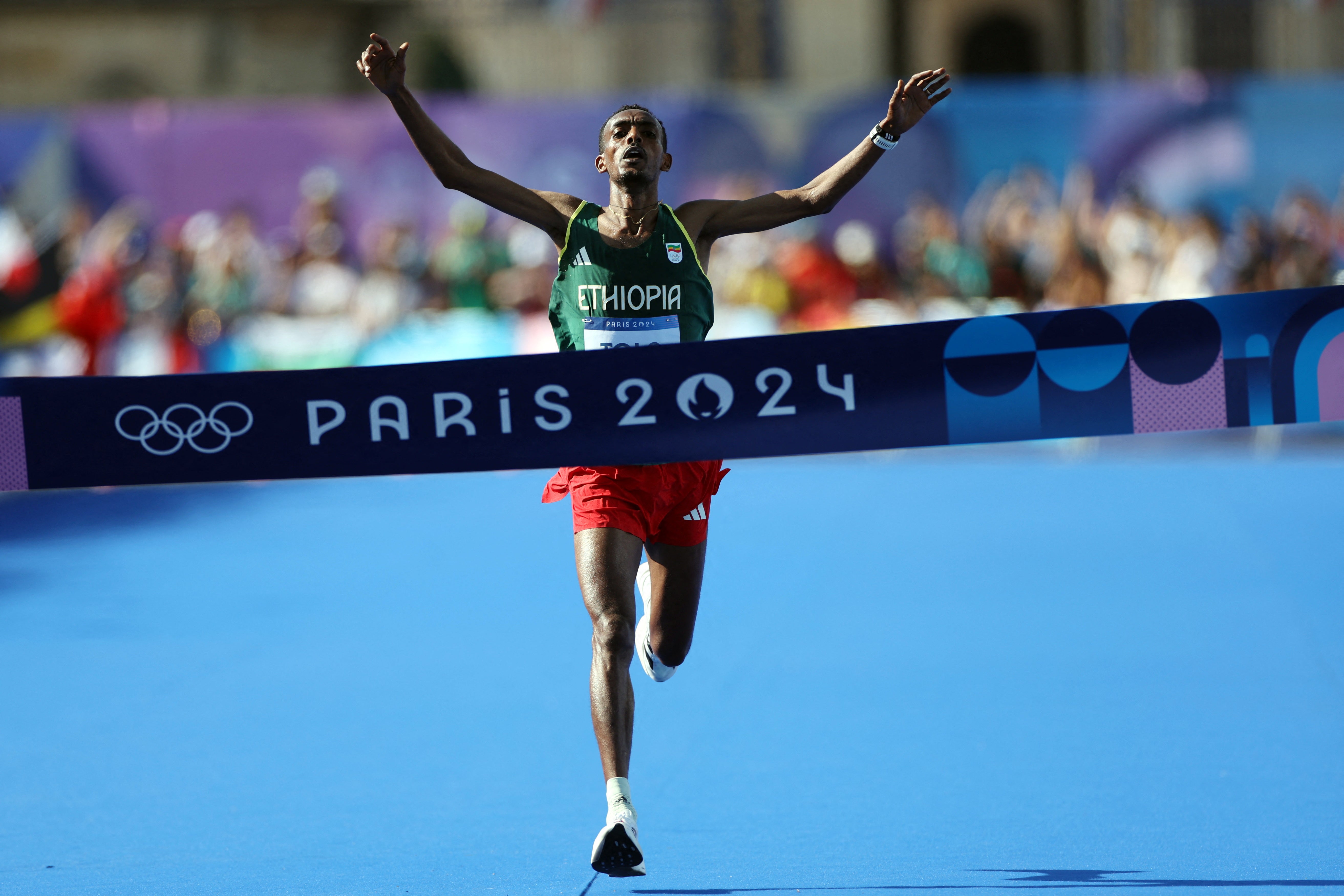 Tamirat Tola of Ethiopia celebrates as he crosses the finish line
