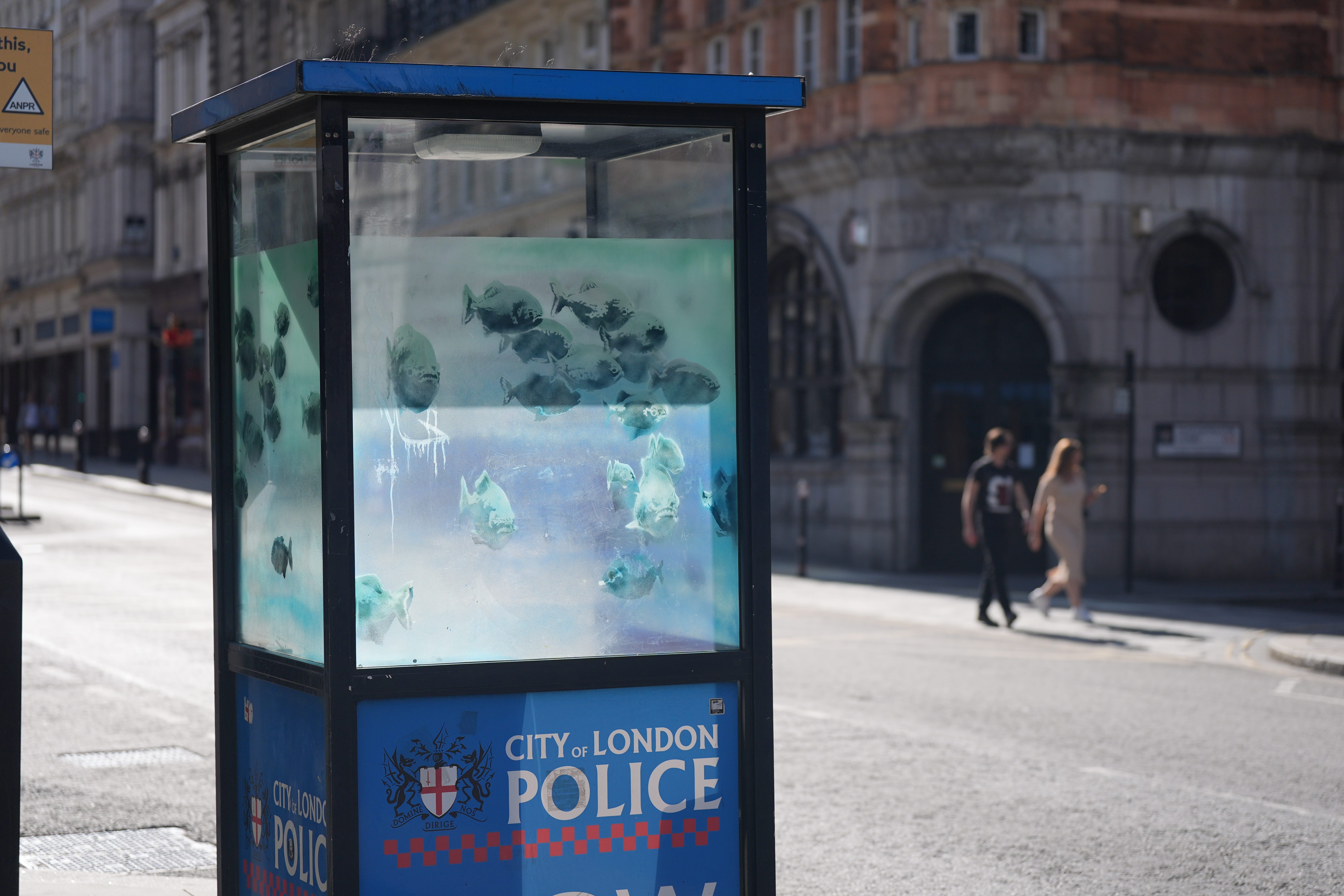 A new artwork of swimming fish has appeared on a police box in the City of London, sparking speculation that it might be the latest Banksy (Yui Mok/PA)