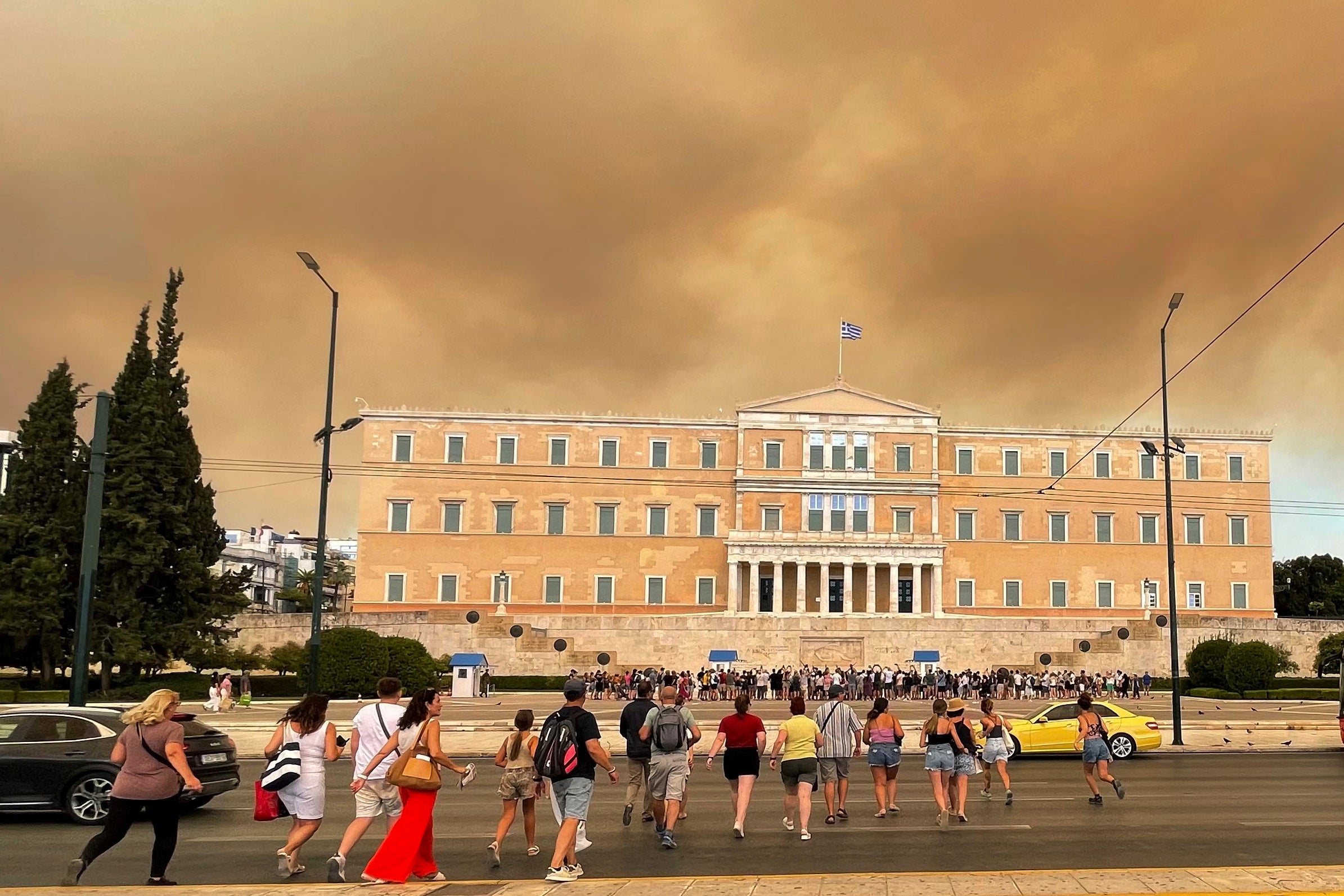 Smoke from wildfires is seen above the Greek parliament building in central Athens on Sunday