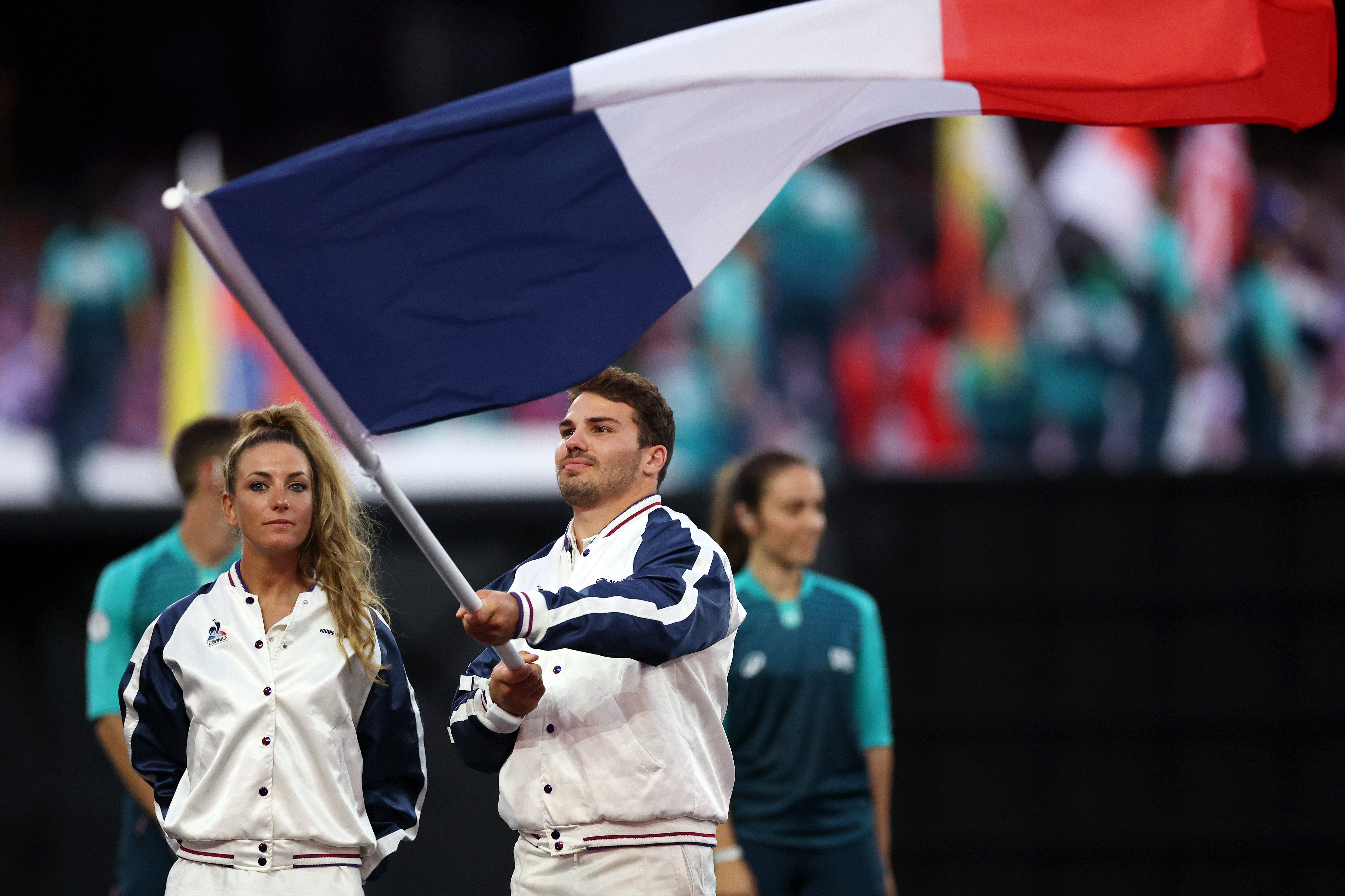 Flagbearers Antoine Dupont and Pauline Ferrand Prevot of Team France