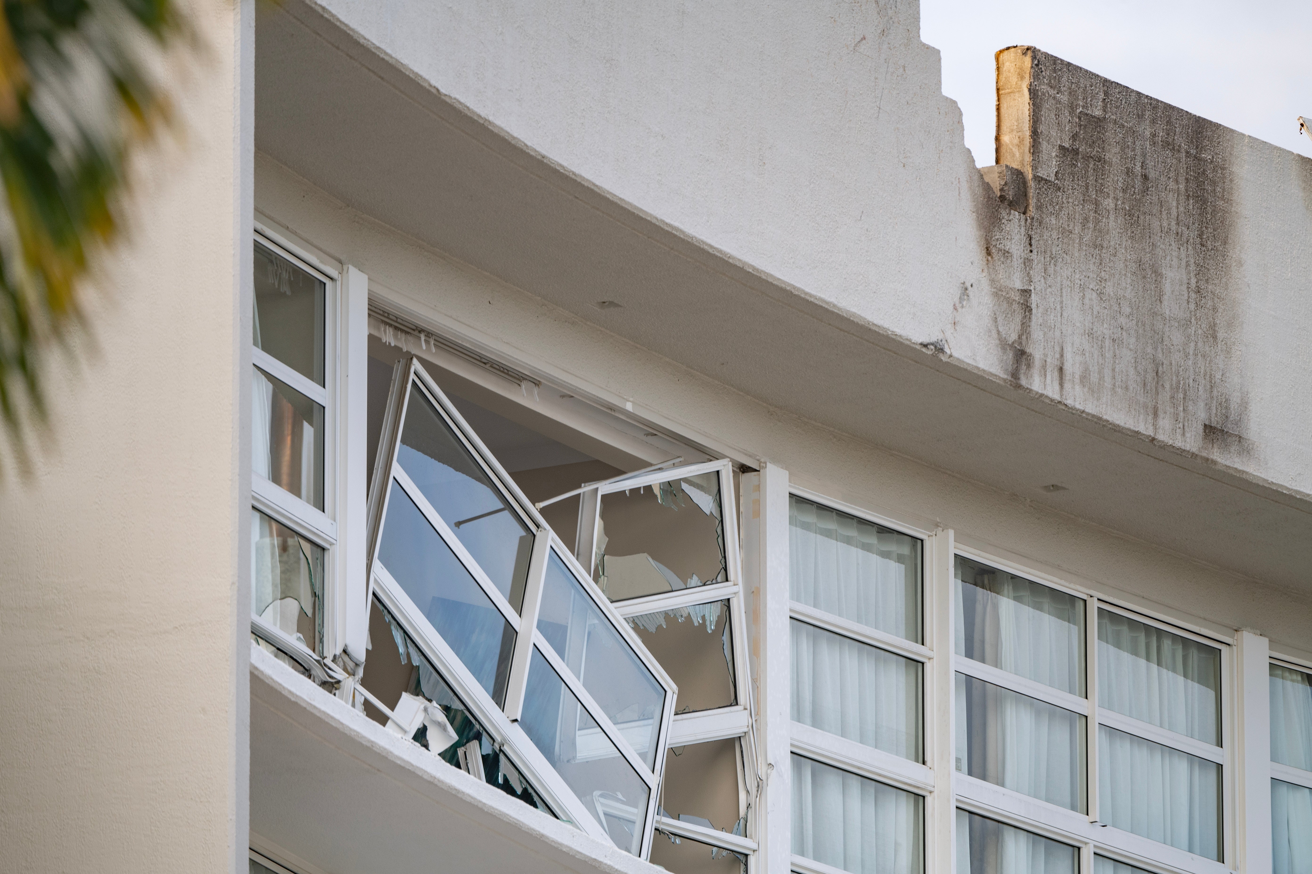 A broken window and damaged rooftop is seen at the Double Tree by Hilton Hotel after a helicopter crashed into its roof in Cairns, Australia, on 12 August 2024