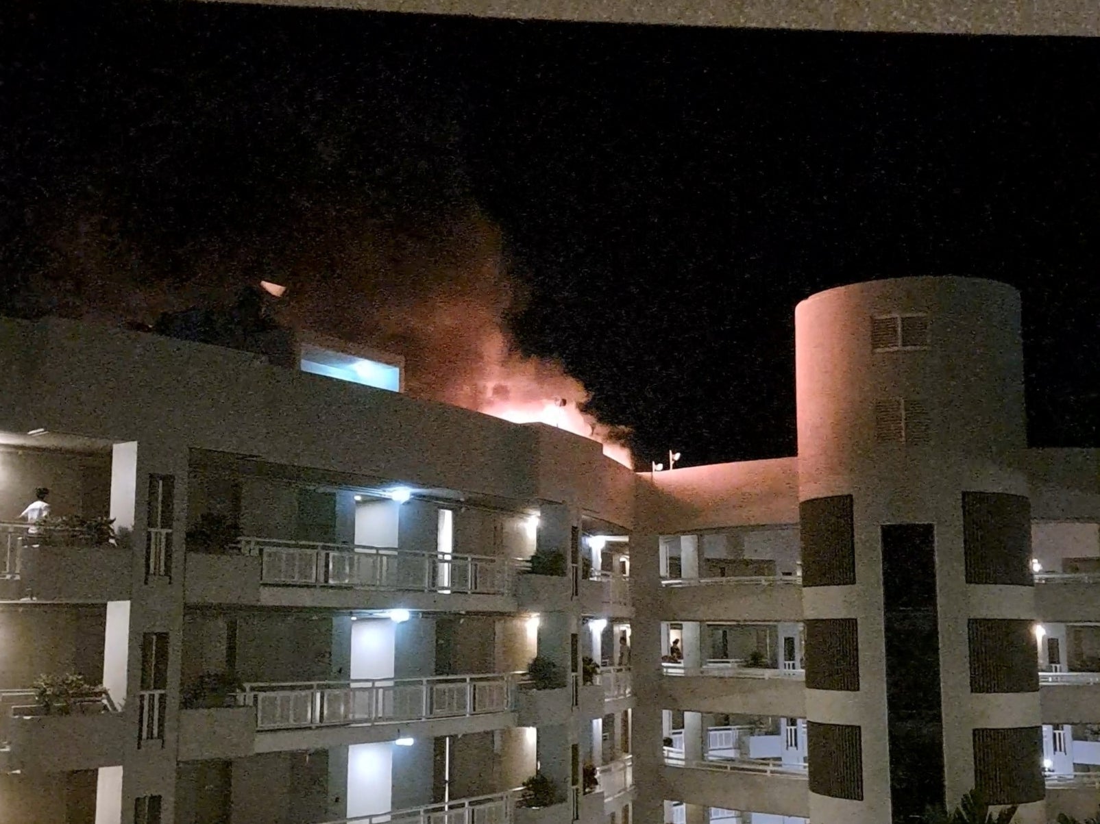 A fire burns at the Double Tree Hotel after a helicopter crashed into the roof in Cairns