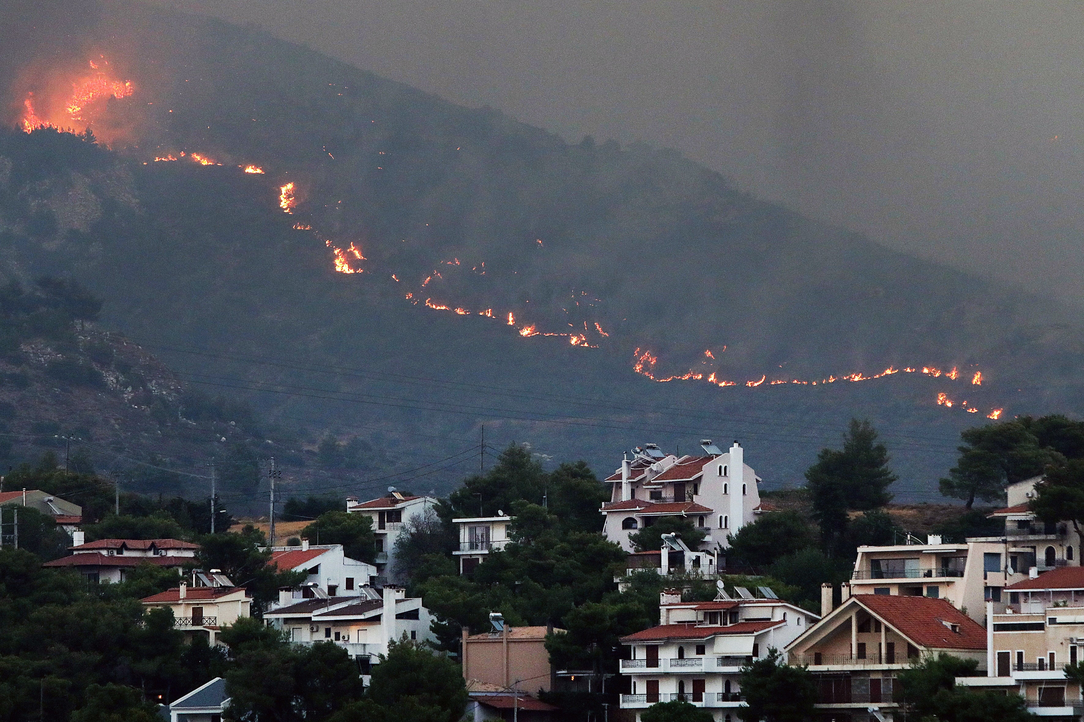 A fire approaches houses at Penteli mount, northeast Attica, Greece, 12 August 2024