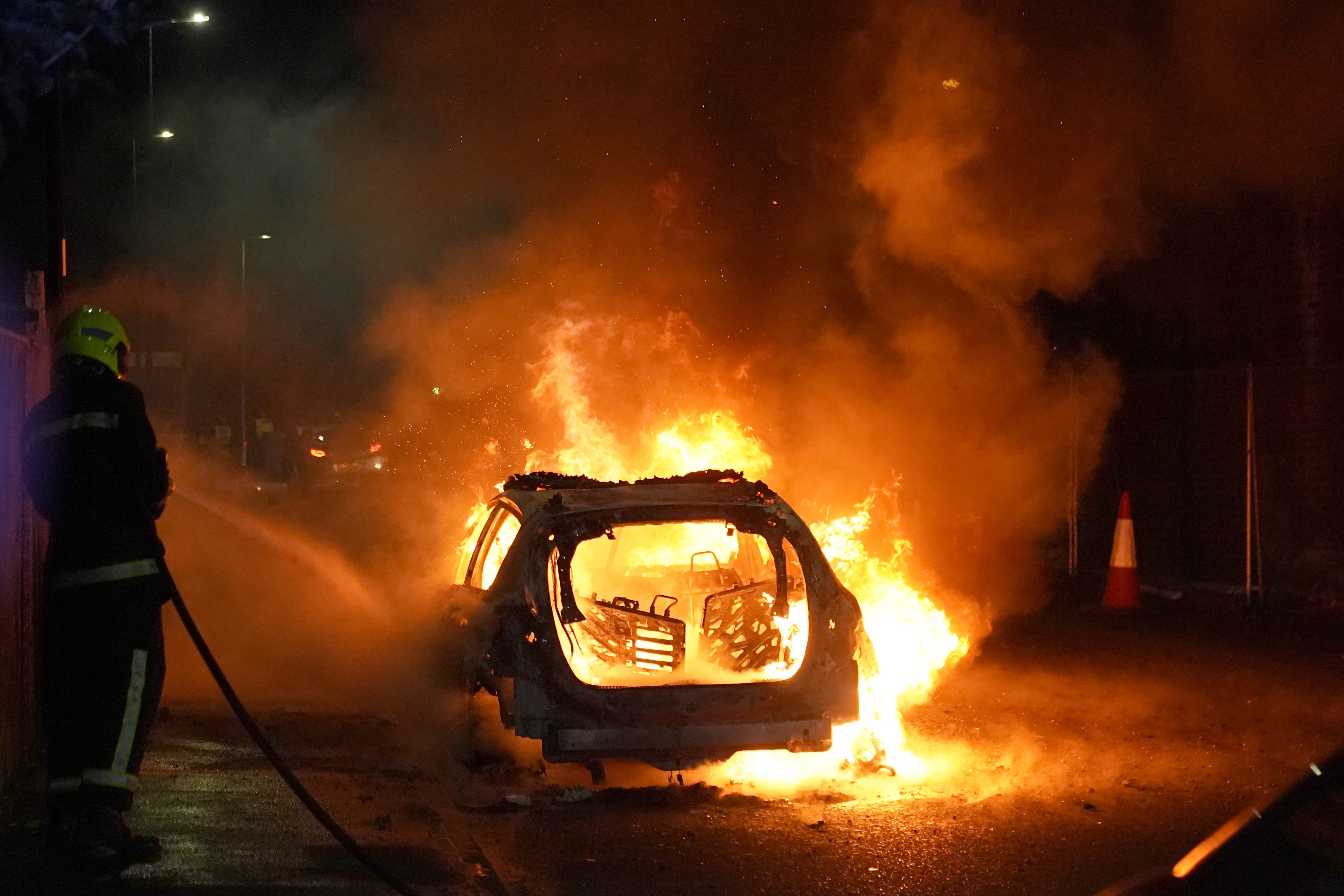 Firefighters tend to a burning police car in Hartlepool during the disorder (Owen Humphreys/PA)