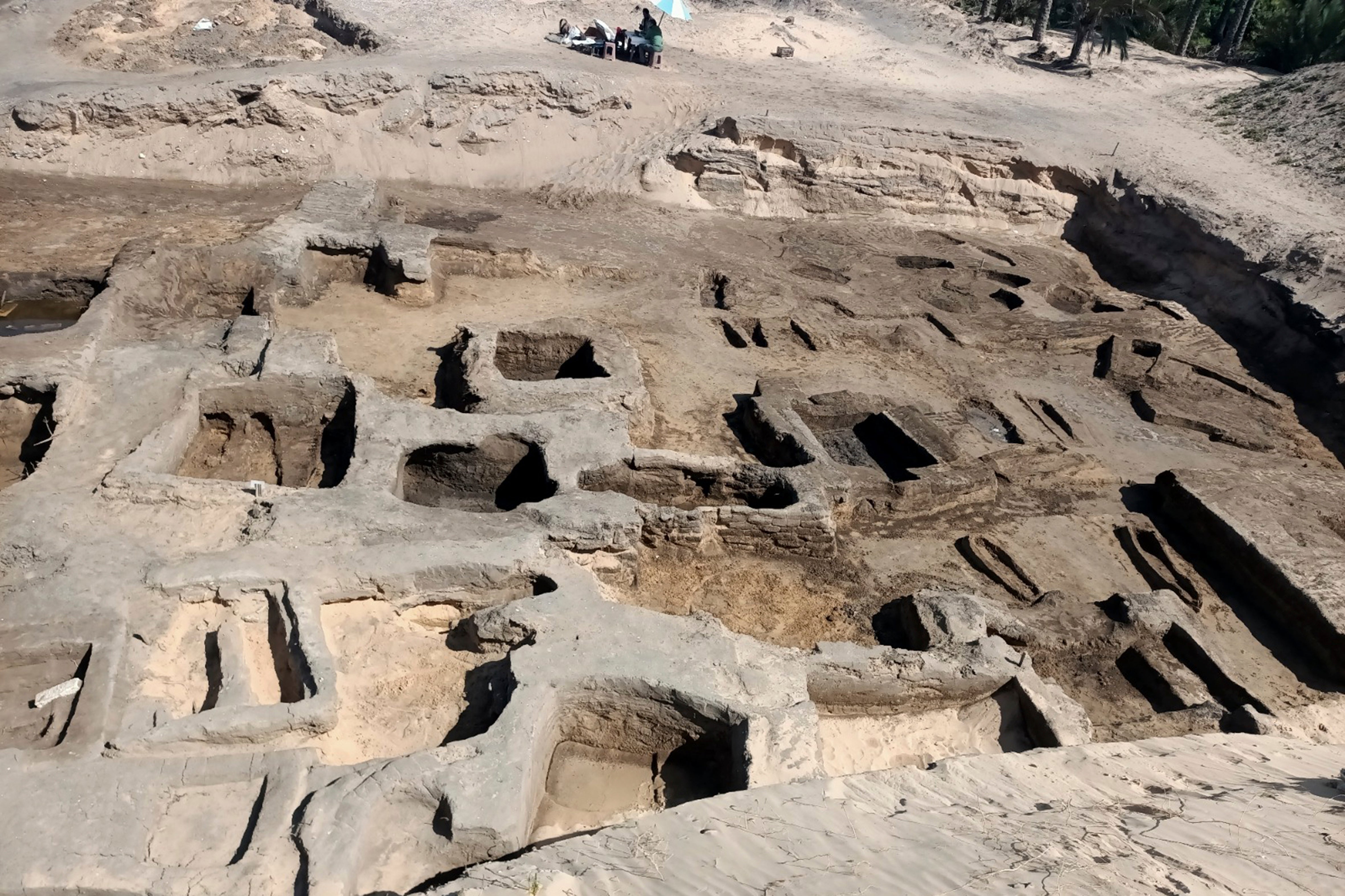 In this image provided by Egypt's Supreme Council of Antiquities, archeologists observe the site where they discovered 63 mud-brick tombs at the Tell al-Deir necropolis, in the Nile Delta town of Damietta, about 125 miles (200 km) north of Cairo, Egypt