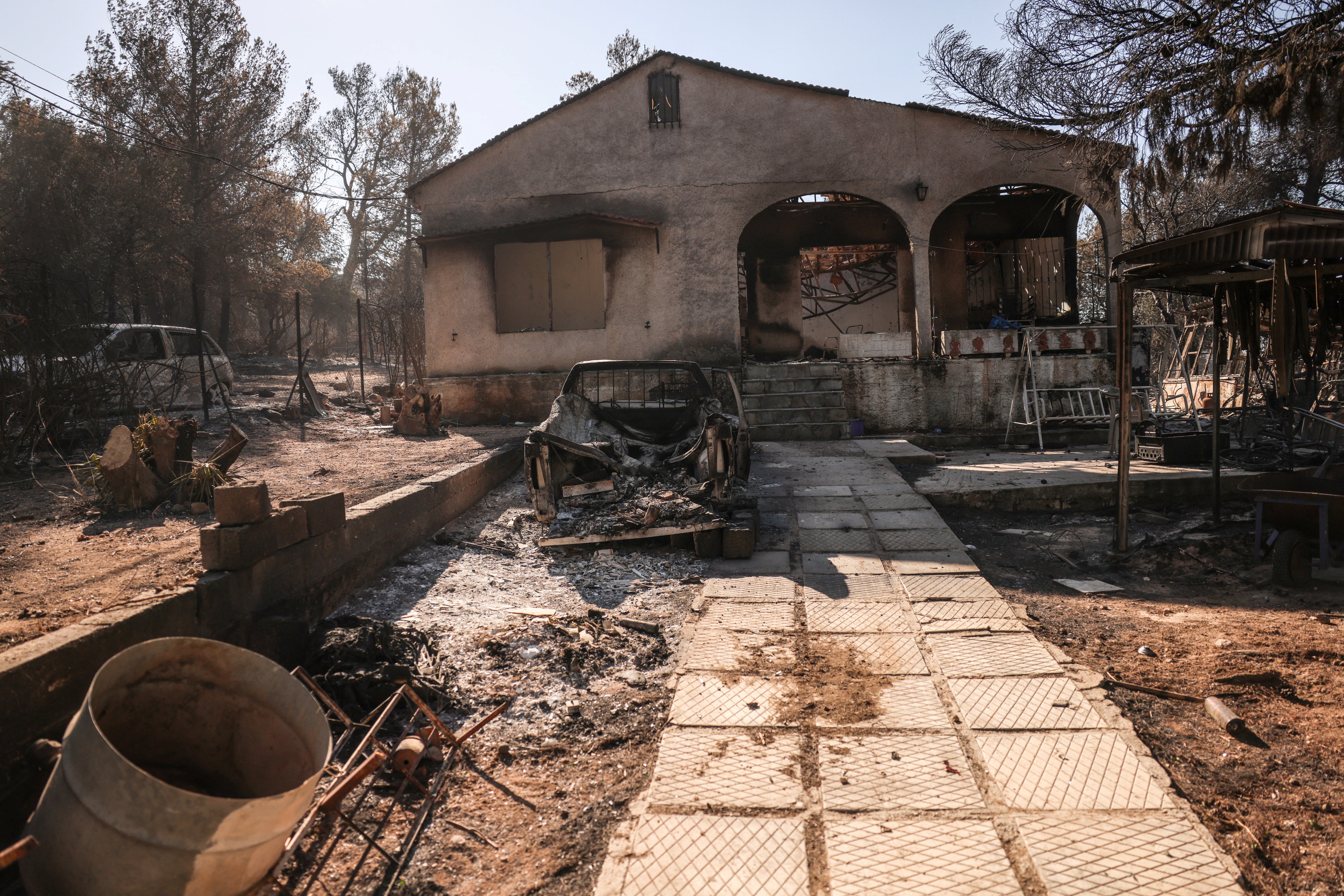 A view of a burned out house and cars following the wildfire in Halandri suburb in Athens, Greece, 13 August 2024