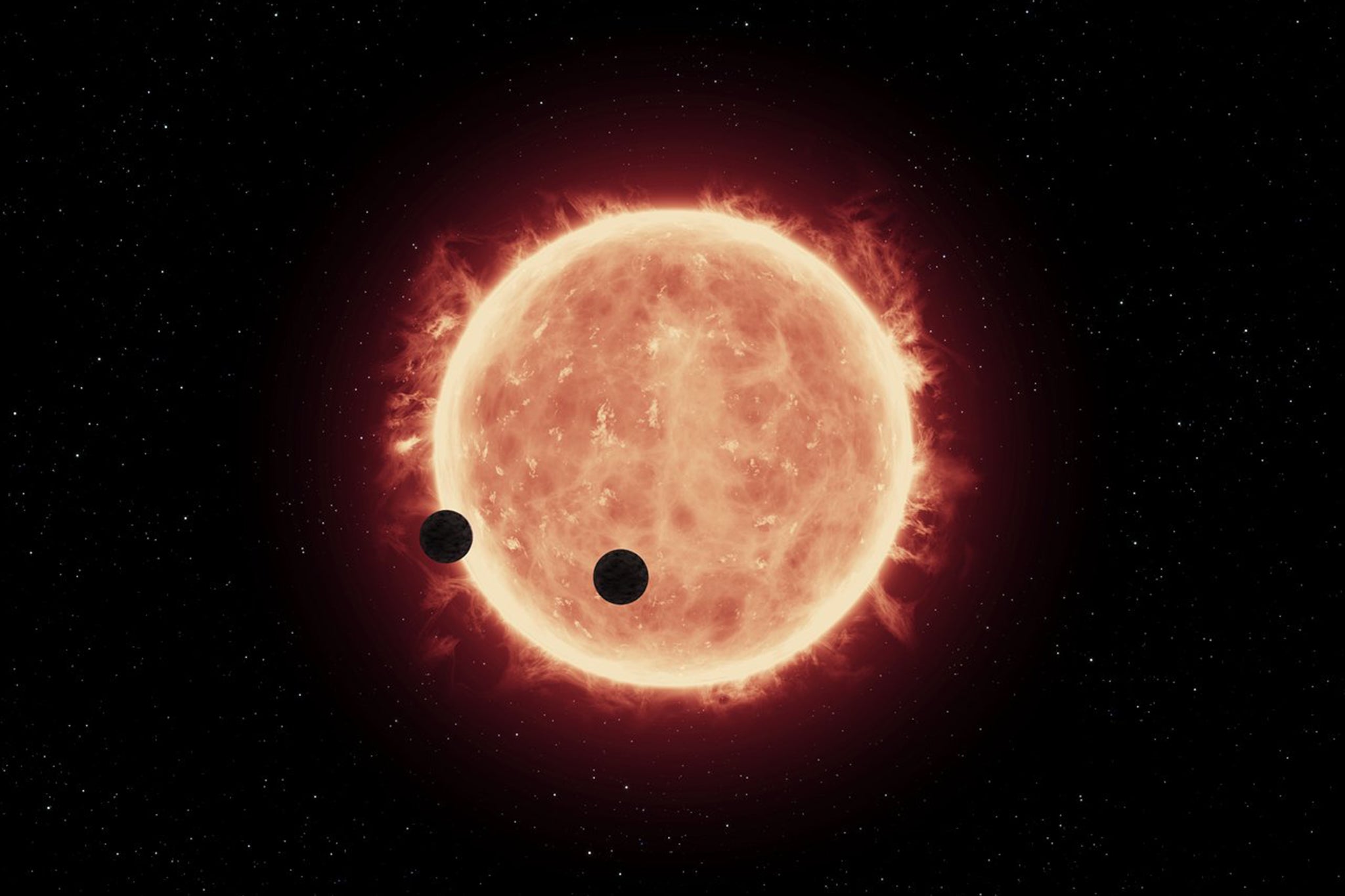 An artist’s impression shows two Trappist-1 exoplanets passing in front of their parent red dwarf star