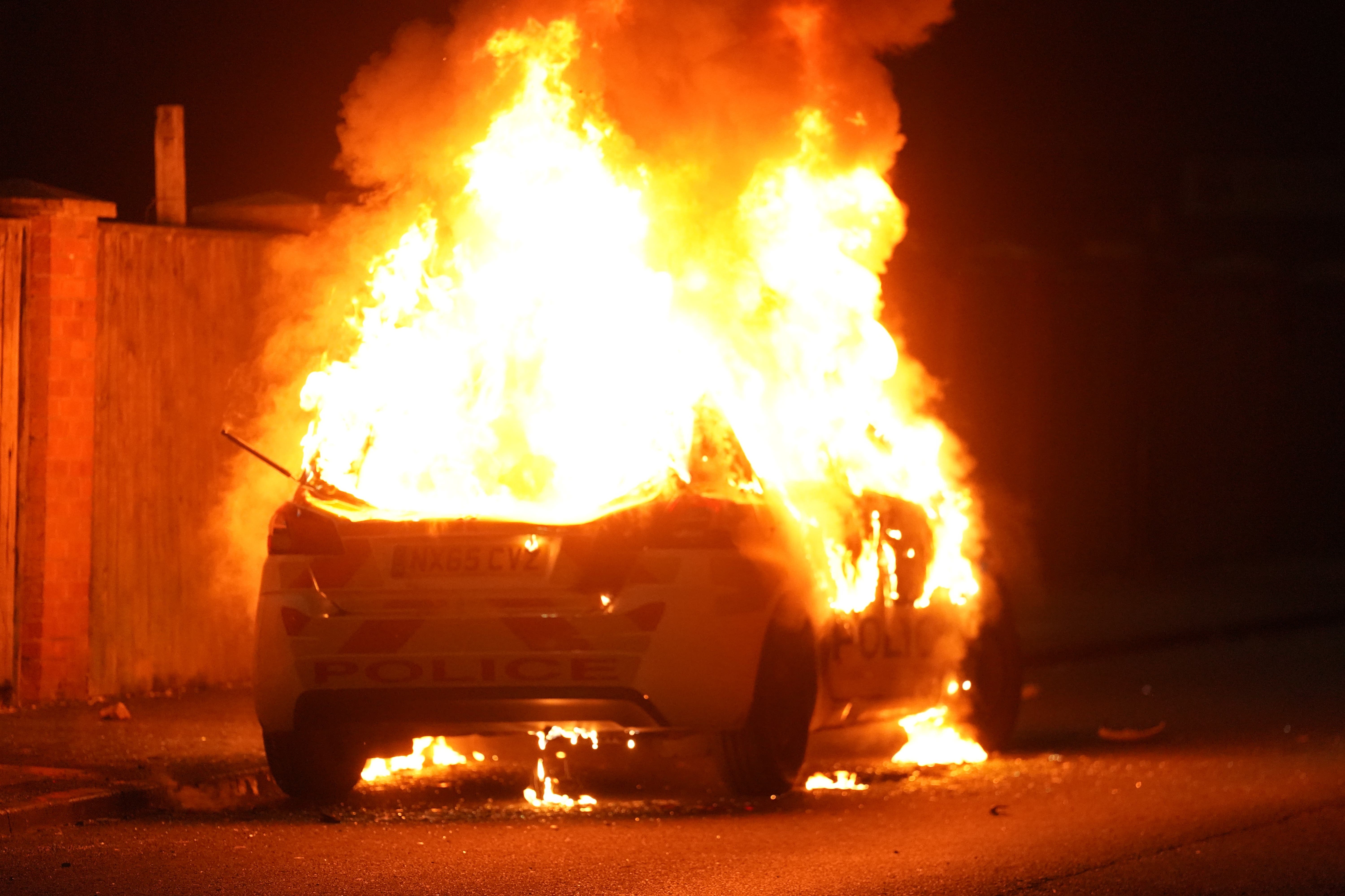 A police car burns as officers are deployed on the streets of Hartlepool (Owen Humphreys/PA)