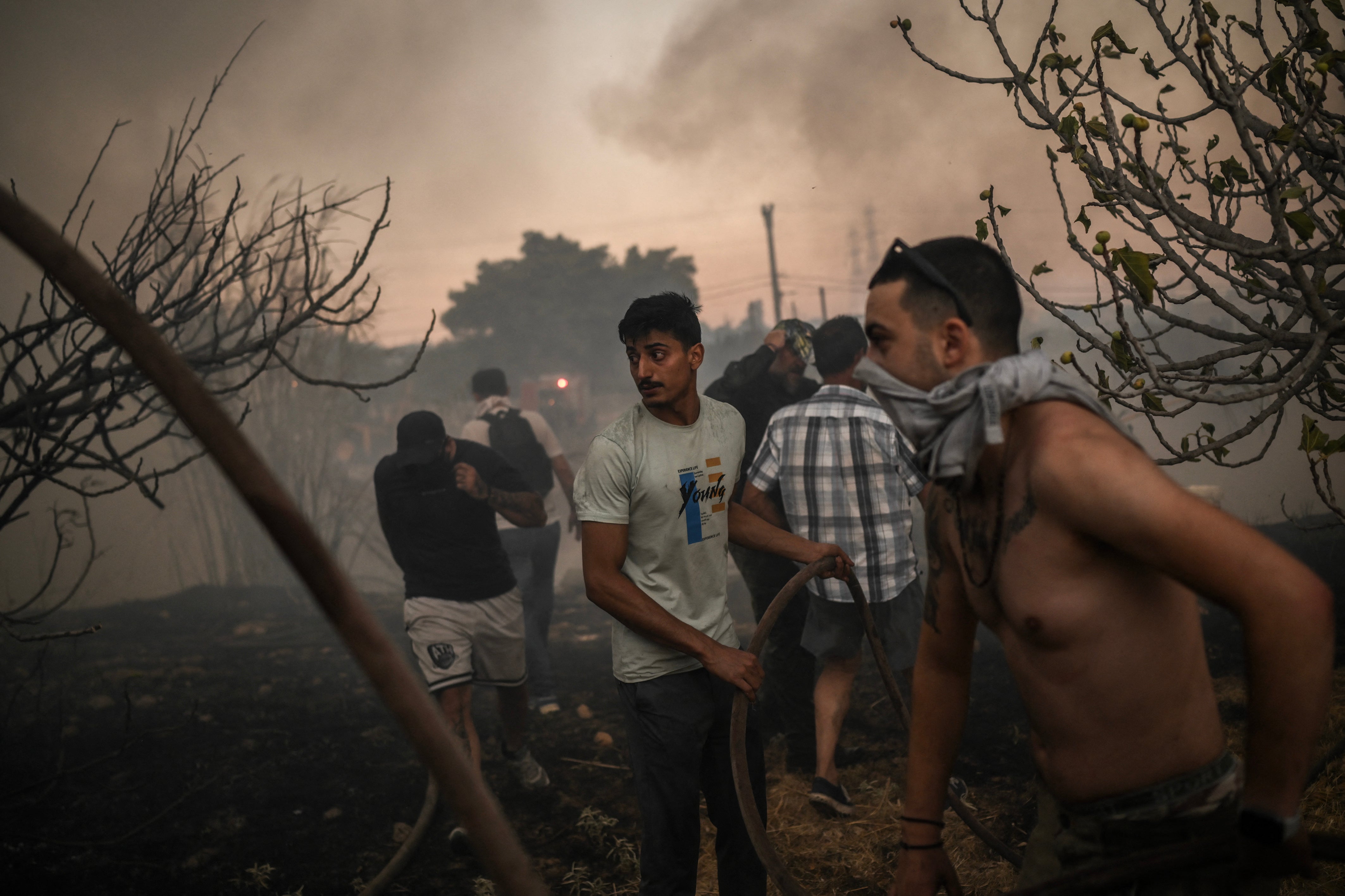 Volunteers try to extinguish a wildfire near Penteli, Greece, on Monday