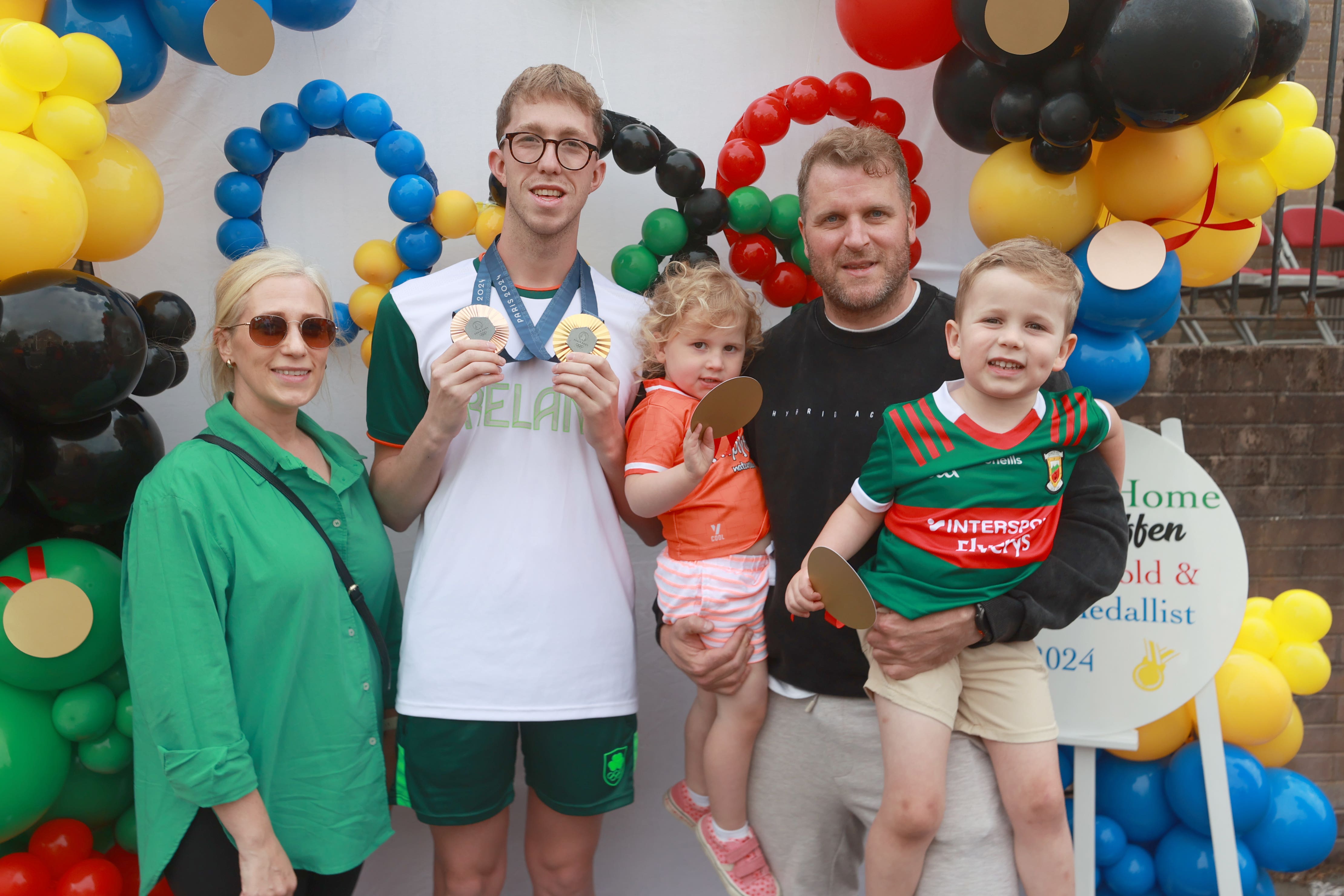 Gold and bronze medal winning swimmer Daniel Wiffen meets Michelle O’Malley, her husband Dessie and their two children Nellie, 3, and Theodore, 4, from Lurgan (Liam McBurney/PA)