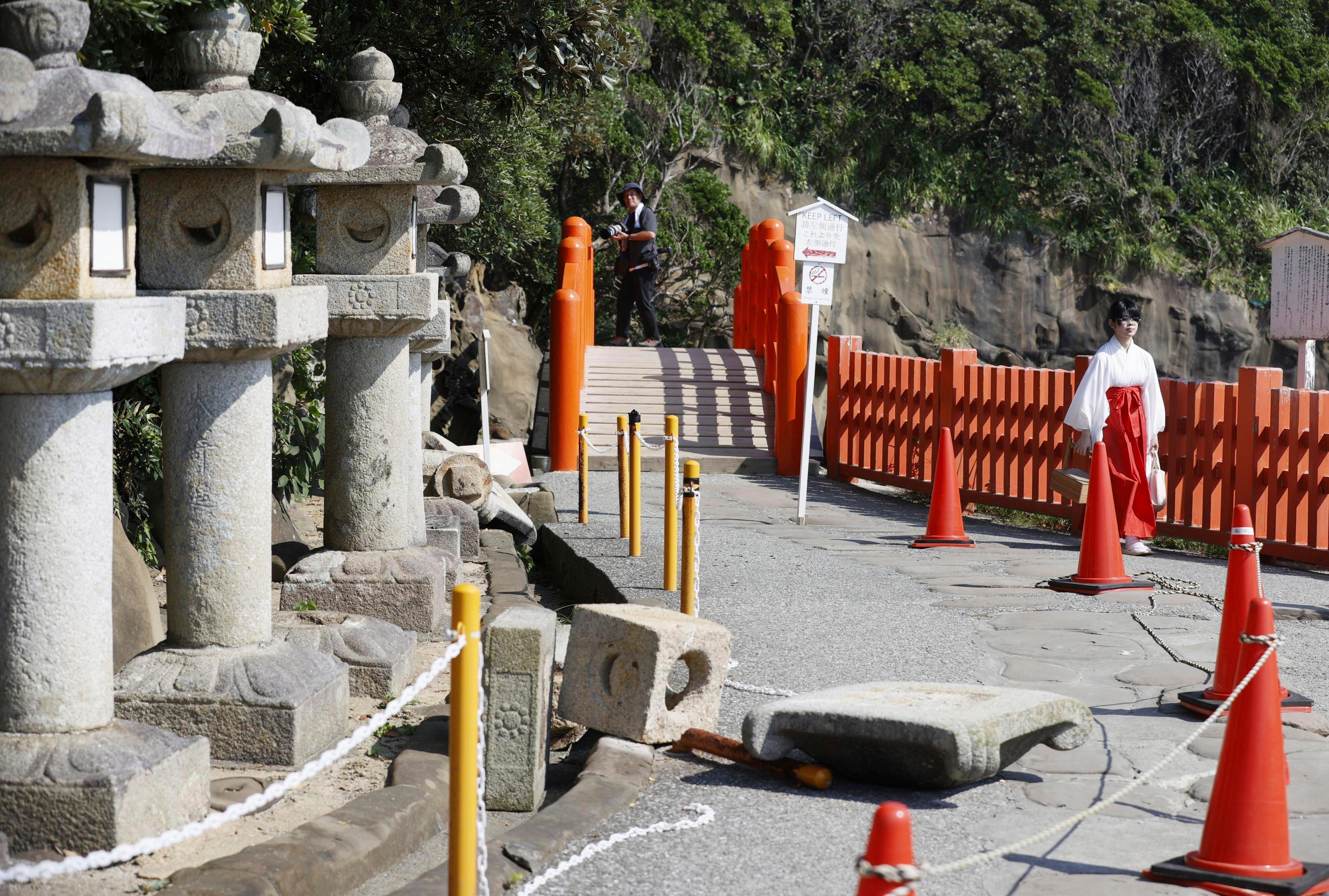 Stone lanterns fall at a shrine following a strong earthquake in Nichinan, Miyazaki prefecture, southern Japan