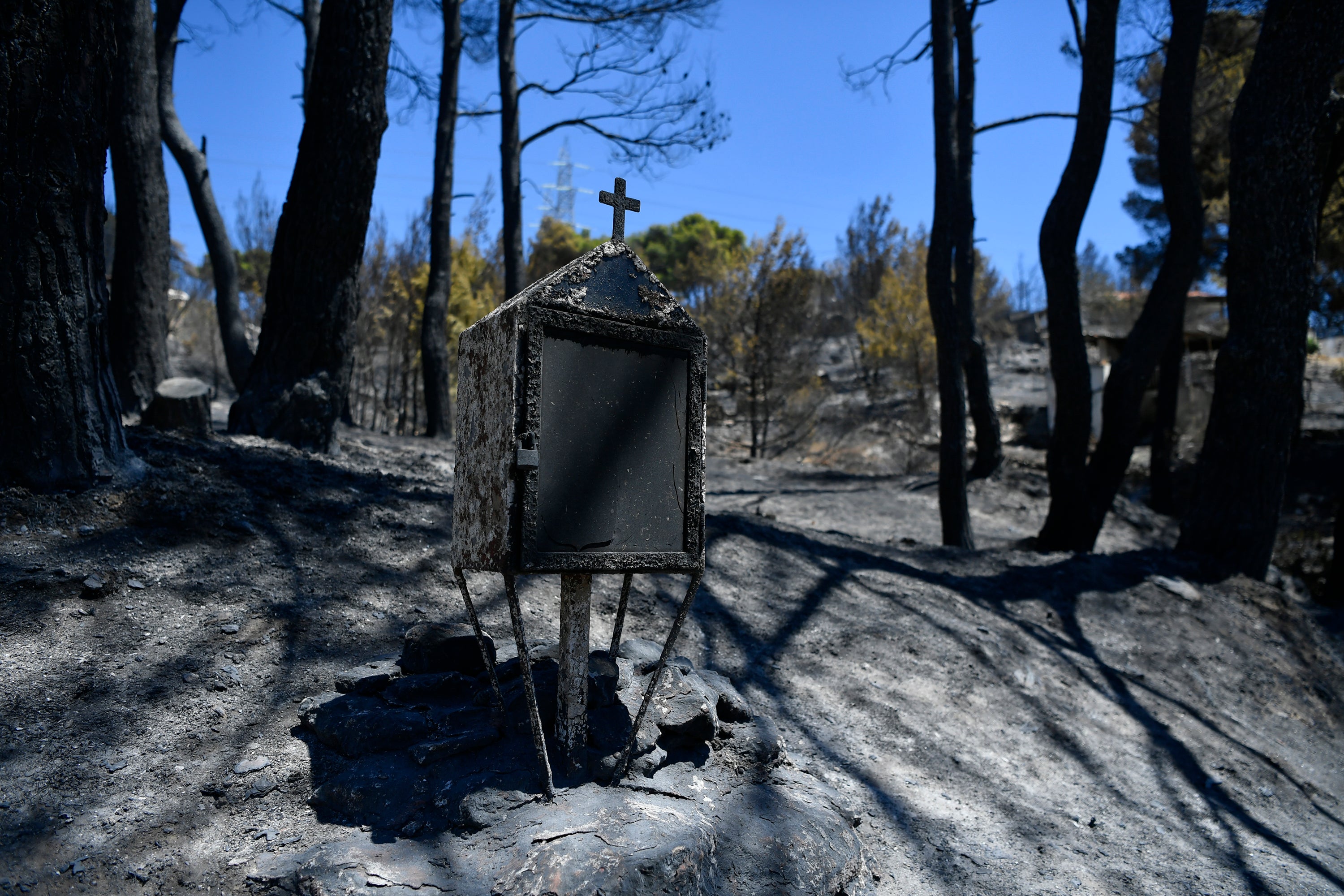 A burned roadside shrine stands in the Nea Penteli suburb of Athens