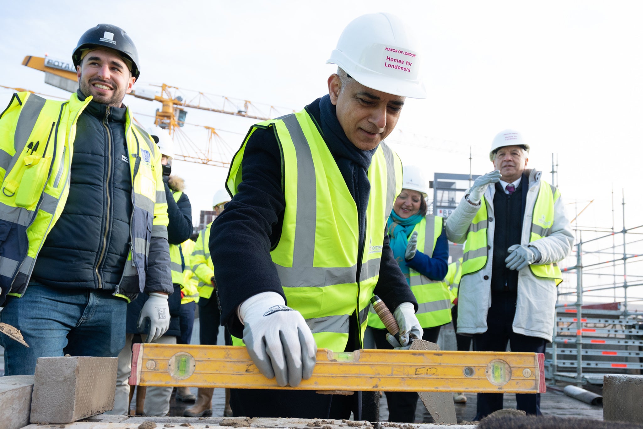 Mayor of London Sadiq Khan tries his hand at bricklaying during the topping out ceremony of a new affordable housing development in the Royal Docks, east London