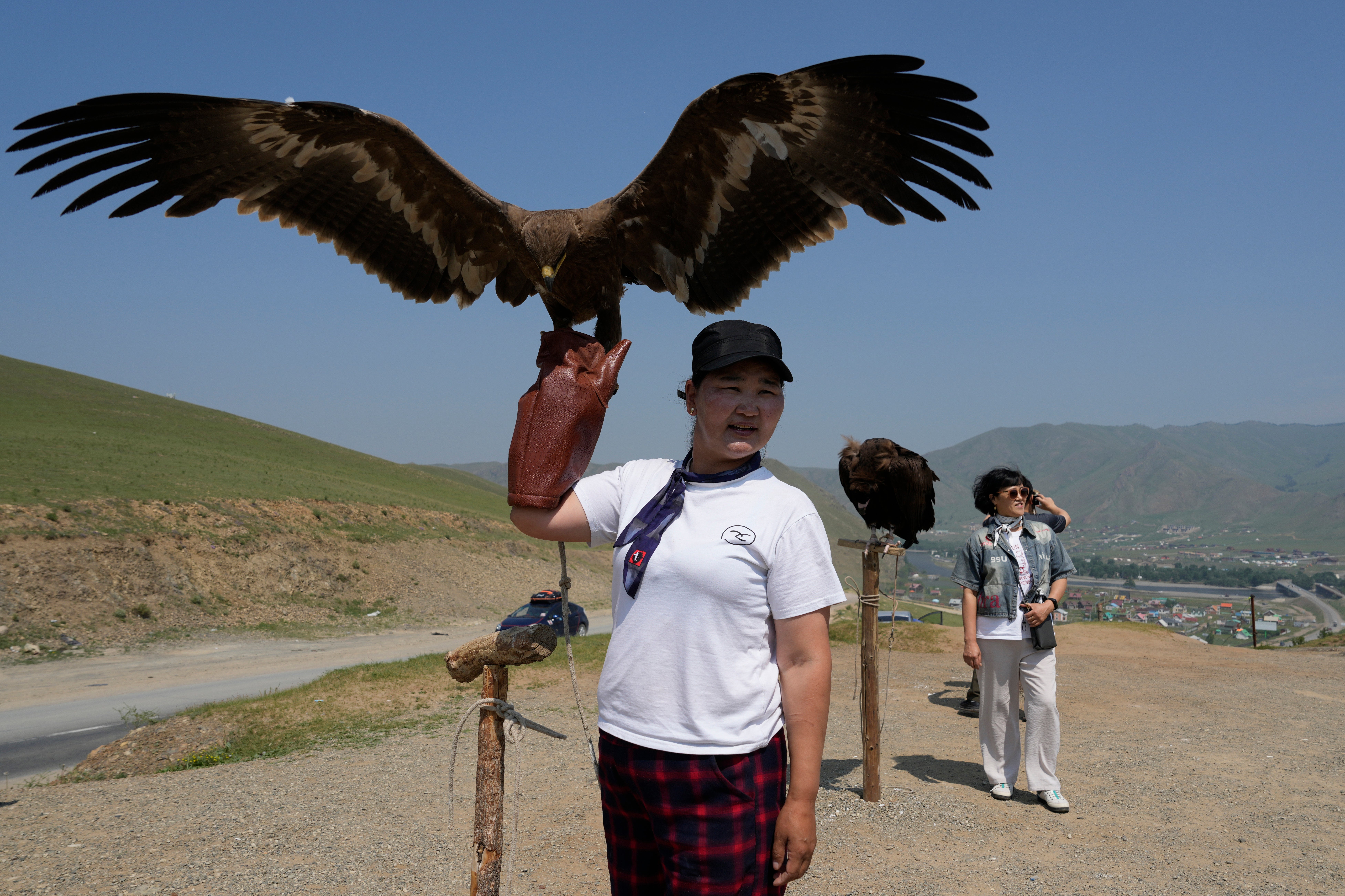 A vendor holds up an eagle as the waits for tourists to take photos with near the Terejl National Park outside Ulaanbaatar, Mongolia