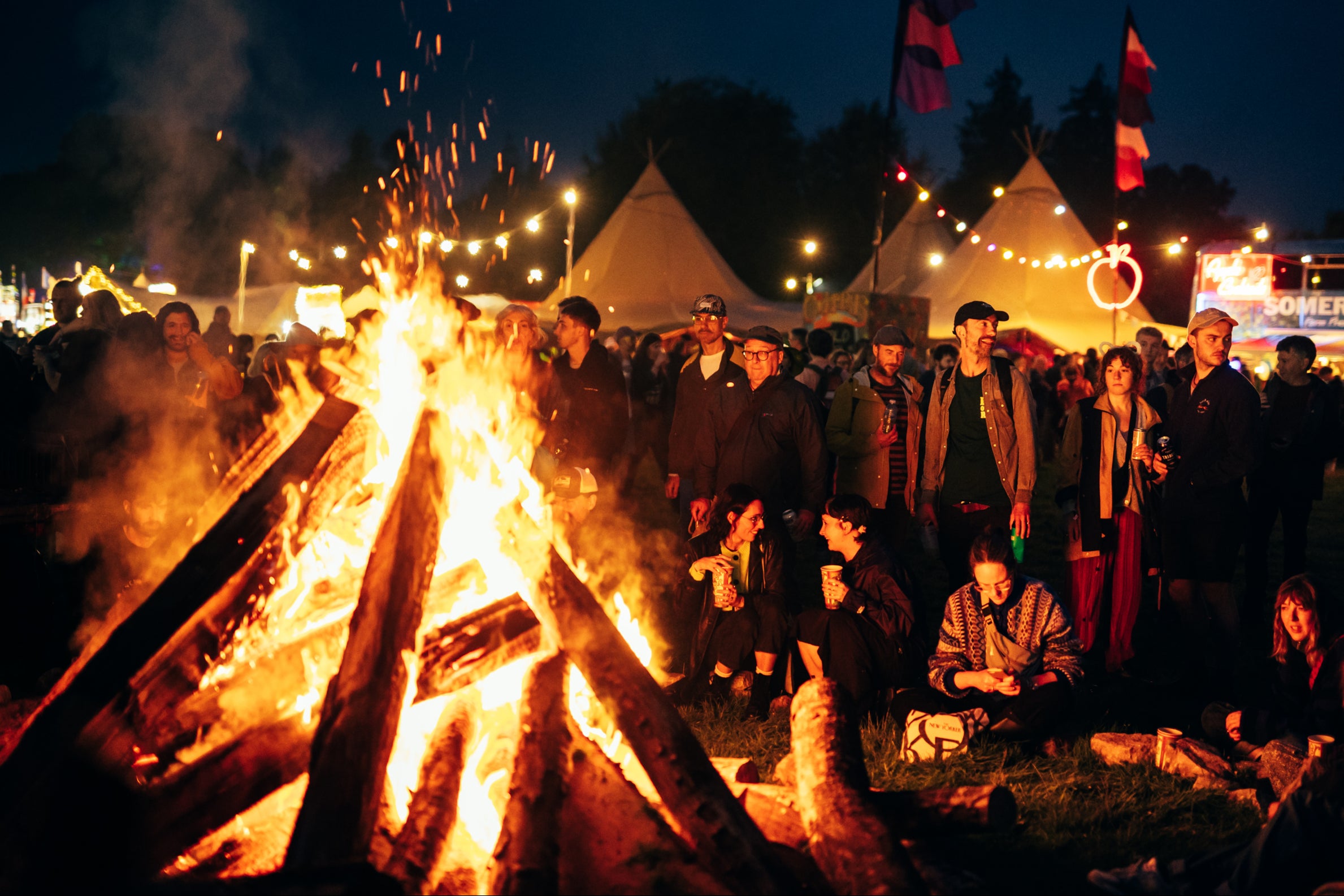 Revellers gather around a fire at End of the Road 2023