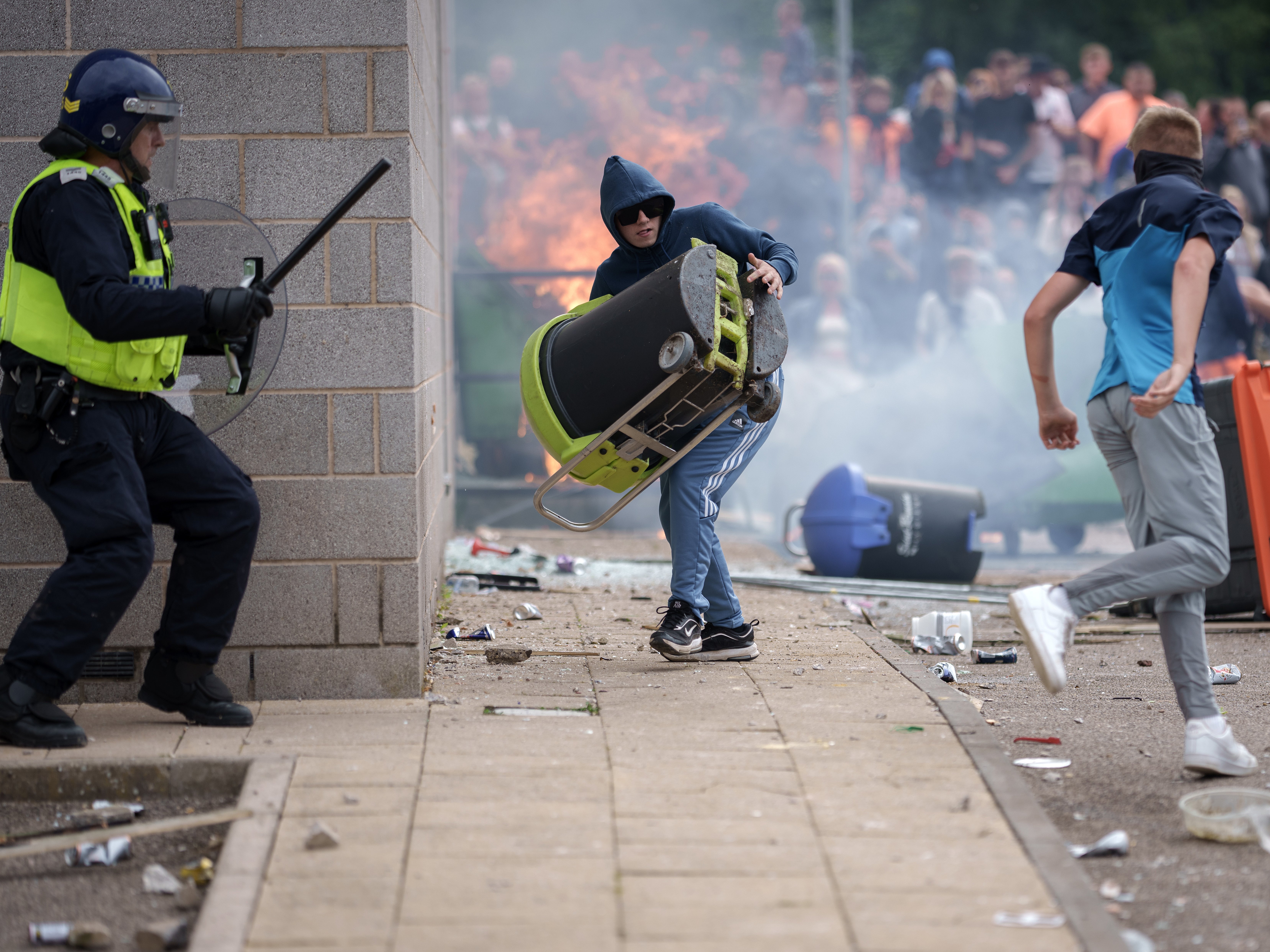 Riot police officers push back anti-migration protesters outside the Holiday Inn Express Hotel in Rotherham